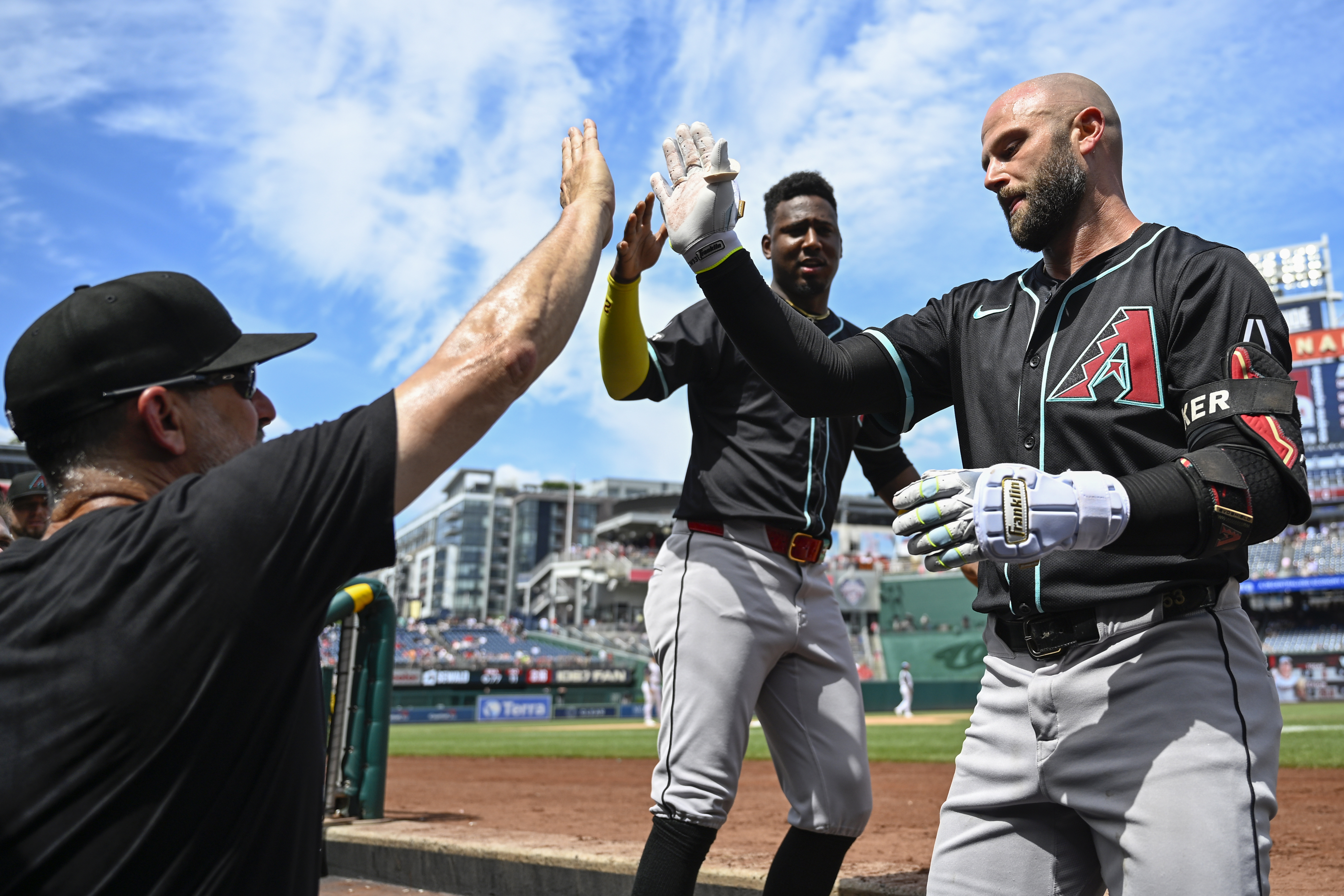 Arizona Diamondbacks manager Torey Lovullo, left, congratulates Diamondbacks' Christian Walker in the dugout on a home run during the ninth inning of a baseball game against the Washington Nationals Thursday, June 20, 2024, in Washington.