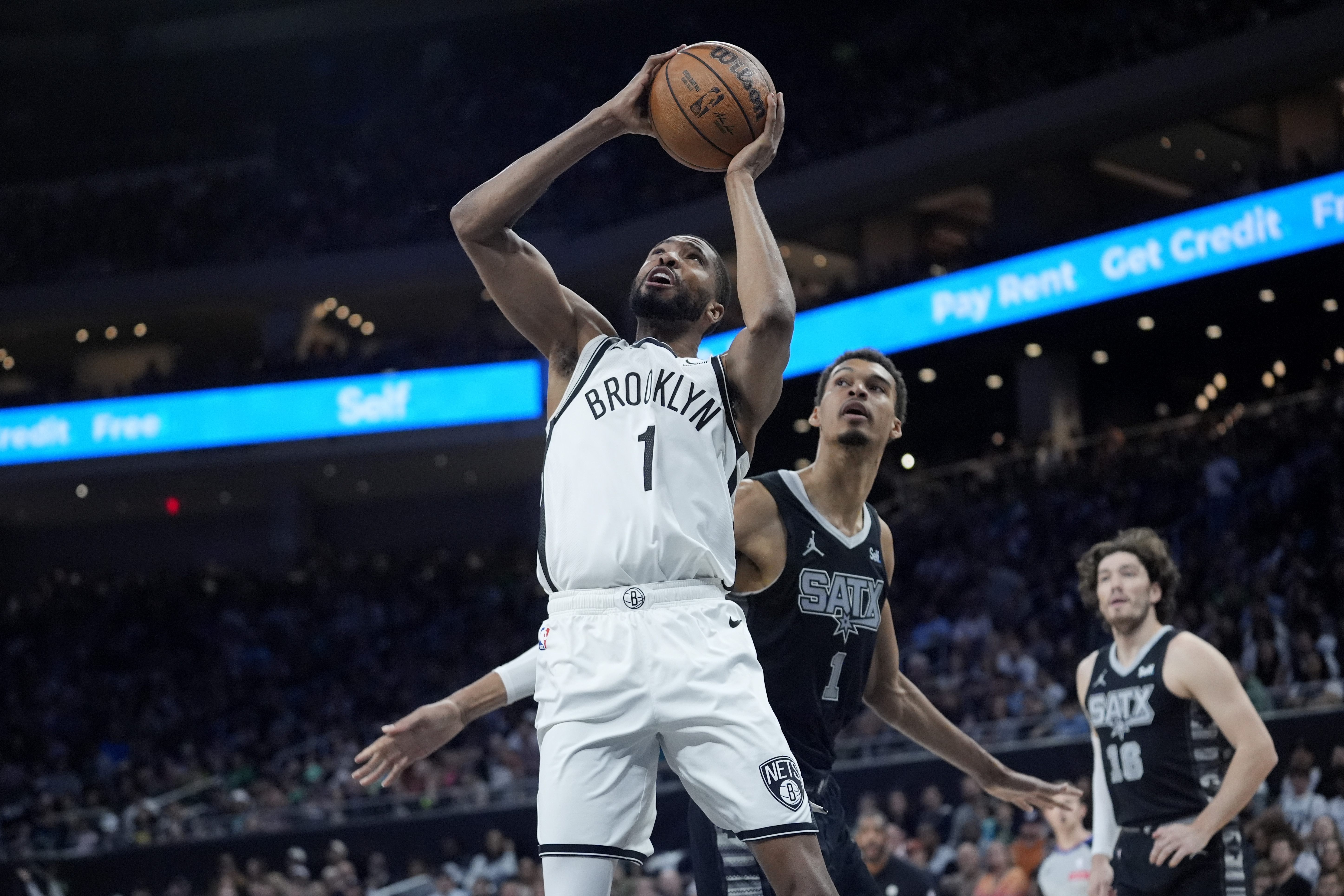 FILE - Brooklyn Nets forward Mikal Bridges, left, scores past San Antonio Spurs center Victor Wembanyama, center, during the first half of an NBA basketball game in Austin, Texas, March 17, 2024. Bridges is being traded from the Nets to the New York Knicks, where he will join Jalen Brunson and other former Villanova teammates, a person with knowledge of the details said Tuesday, June 25. 