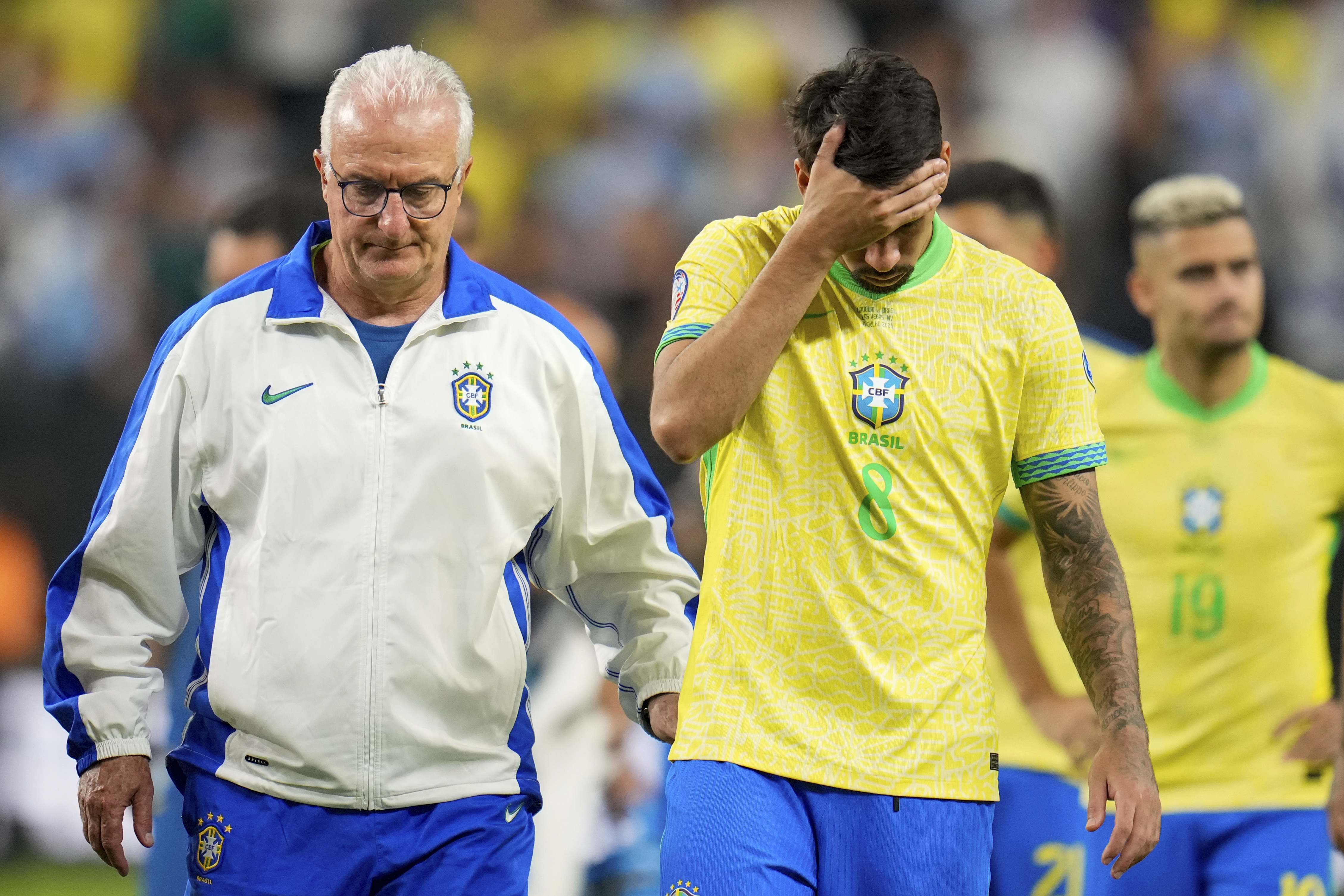 Brazil's coach Dorival Junior, right escorts off the field Lucas Paqueta (8) and teammates after their lost in a penalty shootout against Uruguay during a Copa America quarterfinal soccer match in Las Vegas, Saturday, July 6, 2024.