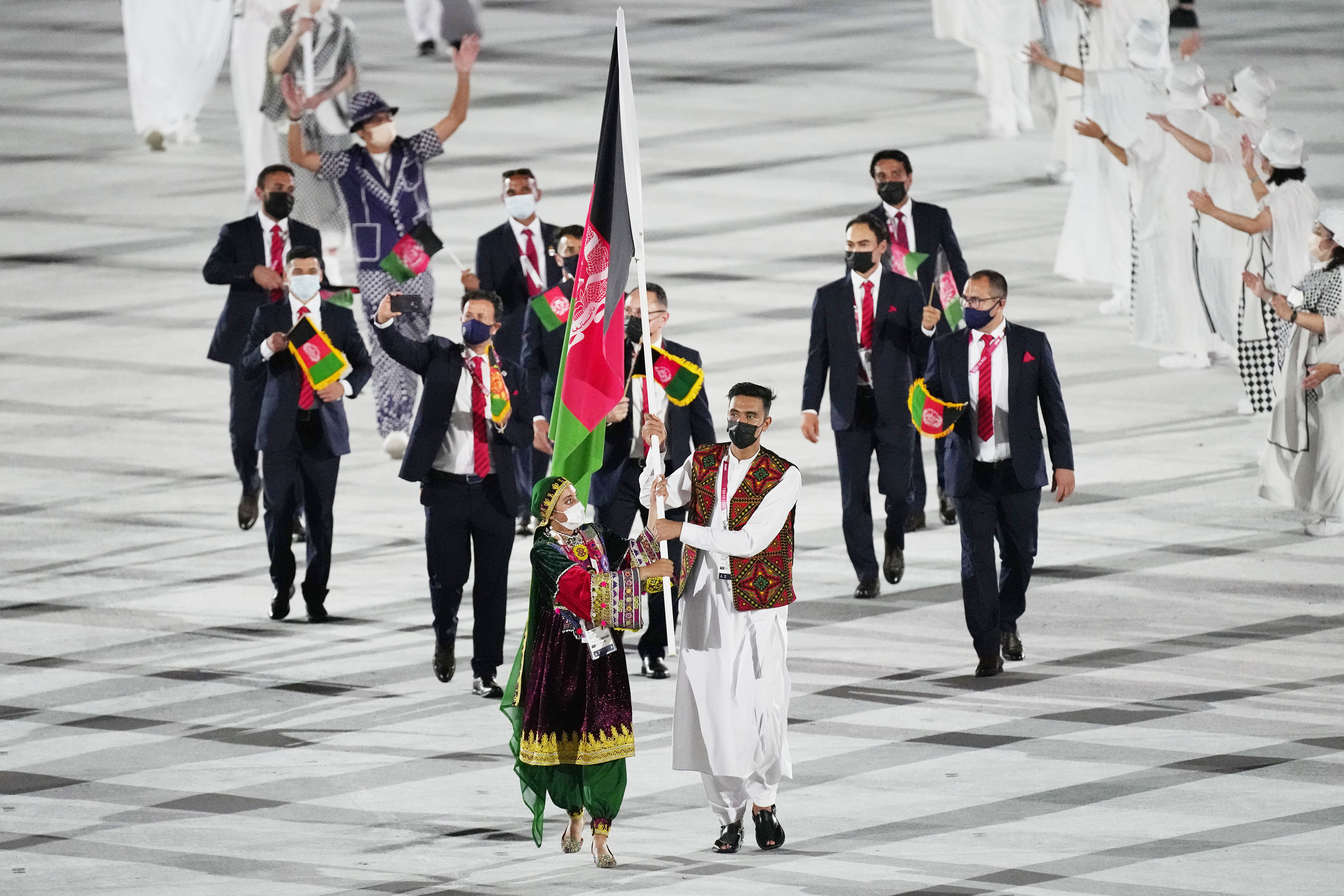 FILE - Kimia Yousofi, front left, and Farzad Mansouri, of Afghanistan, carry their country's flag during the opening ceremony in the Olympic Stadium at the 2020 Summer Olympics on July 23, 2021, in Tokyo, Japan. Afghan sprinter Yousofi is preparing to compete at her third Olympics after being selected for the Paris Games from her training base in Australia. The Australian Olympic Committee on Tuesday, July 9, 2024, congratulated Yousofi on her selection for the women's 100-meter sprint.