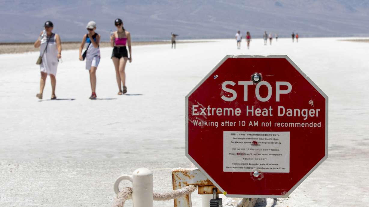 A stop sign warns tourists of extreme heat at Badwater Basin, Monday, in Death Valley National Park, Calif.