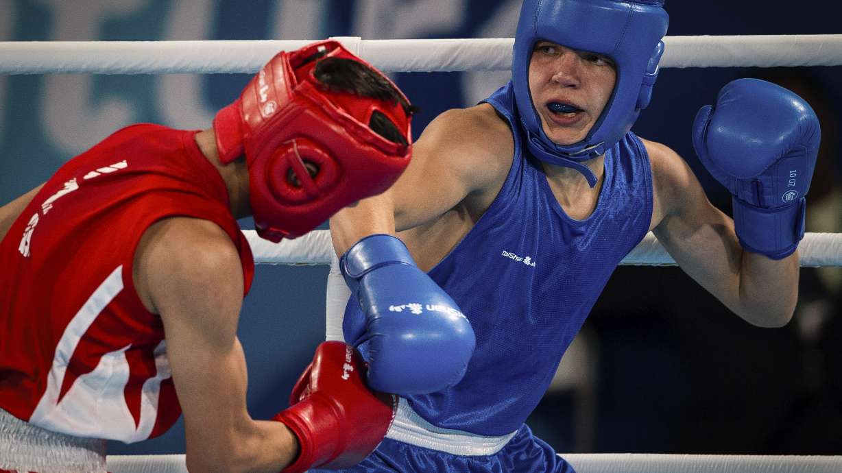 In this photo provided by the International Olympic Committee, Maksym Halinichev of Ukraine, right, competes against Abdumalik Khalokov of Uzbekistan in the Boxing Men's Bantam (56kg) Gold Medal Bout at the Oceania Pavilion of Youth Olympic Park during the Youth Olympic Games in Buenos Aires, Argentina, Thursday, Oct. 18, 2018. As one of Ukraine’s most promising boxing prospects, Halinichev could have been shielded from the war.