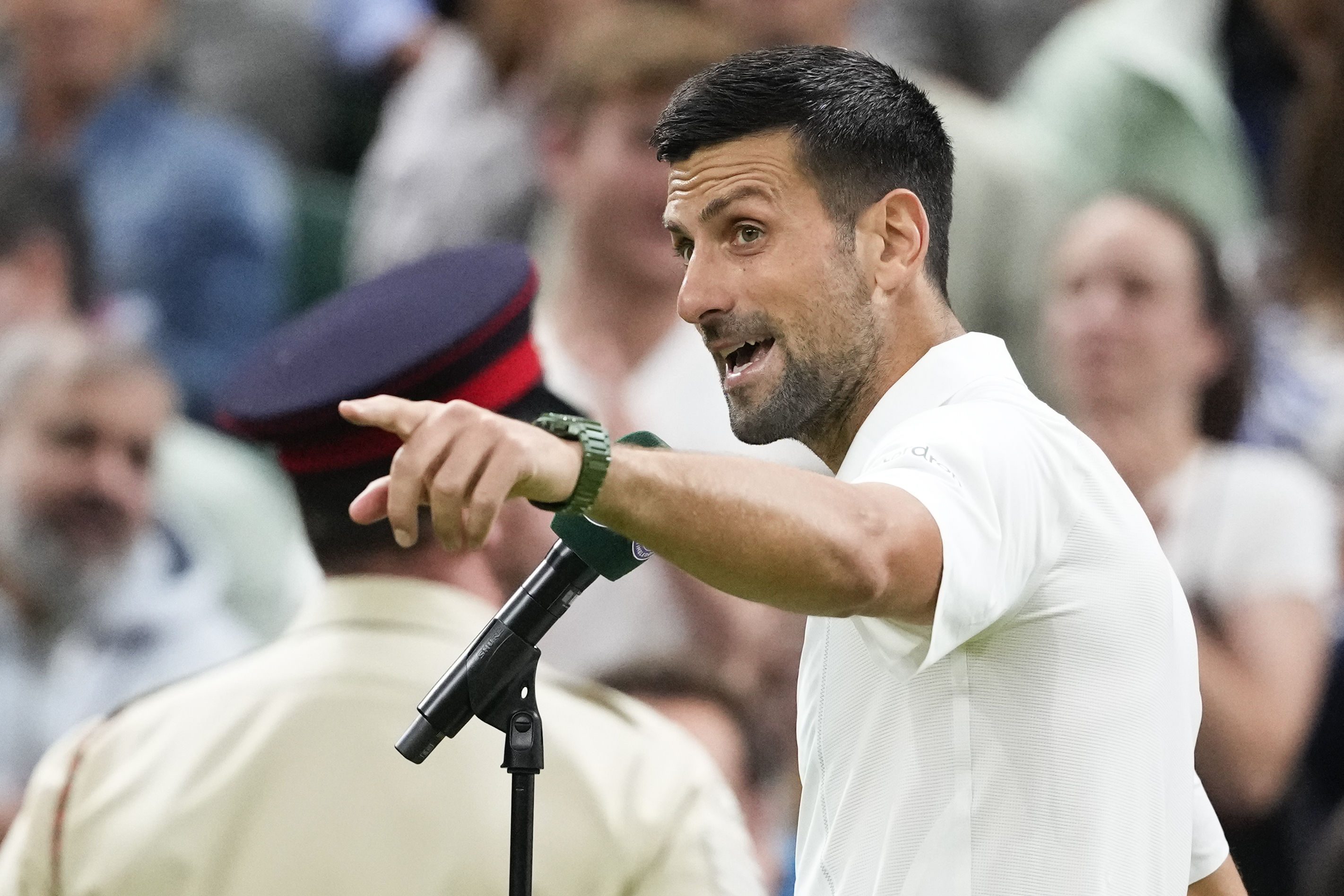 Novak Djokovic of Serbia gestures to the crowd as he is interviewed after defeating Holger Rune of Denmark in their fourth round match at the Wimbledon tennis championships in London, Monday, July 8, 2024.