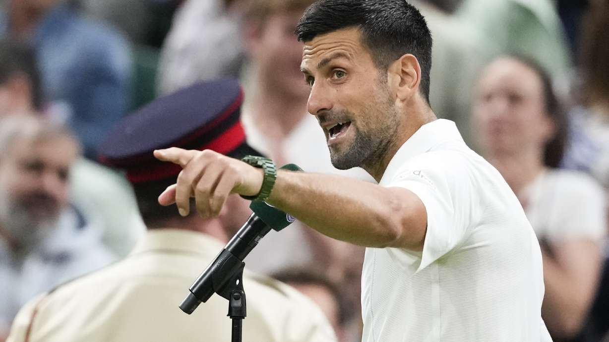 Novak Djokovic of Serbia gestures to the crowd as he is interviewed after defeating Holger Rune of Denmark in their fourth round match at the Wimbledon tennis championships in London, Monday, July 8, 2024.