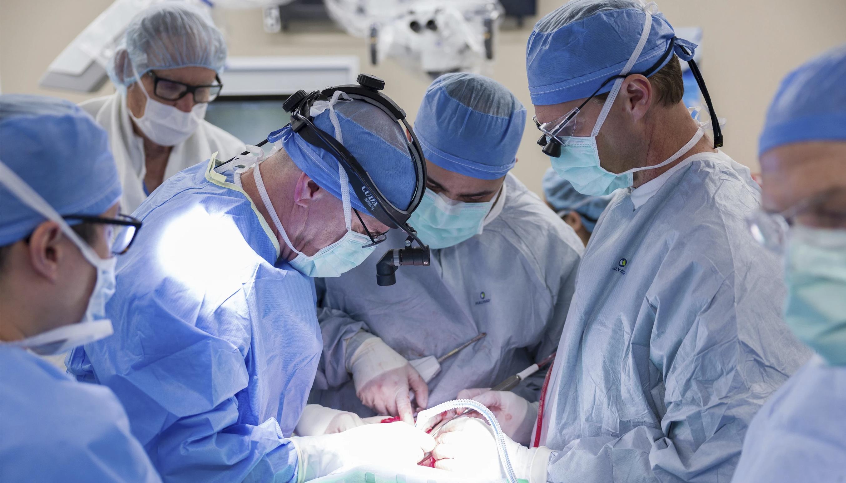 Dr. Michael Hinni, center left, Dr. Payam Entezami, center, and Dr. David Lott, center right, operate on transplant patient Marty Kedian in Phoenix, Feb. 29. Transplants of the so-called voice box are extremely rare.