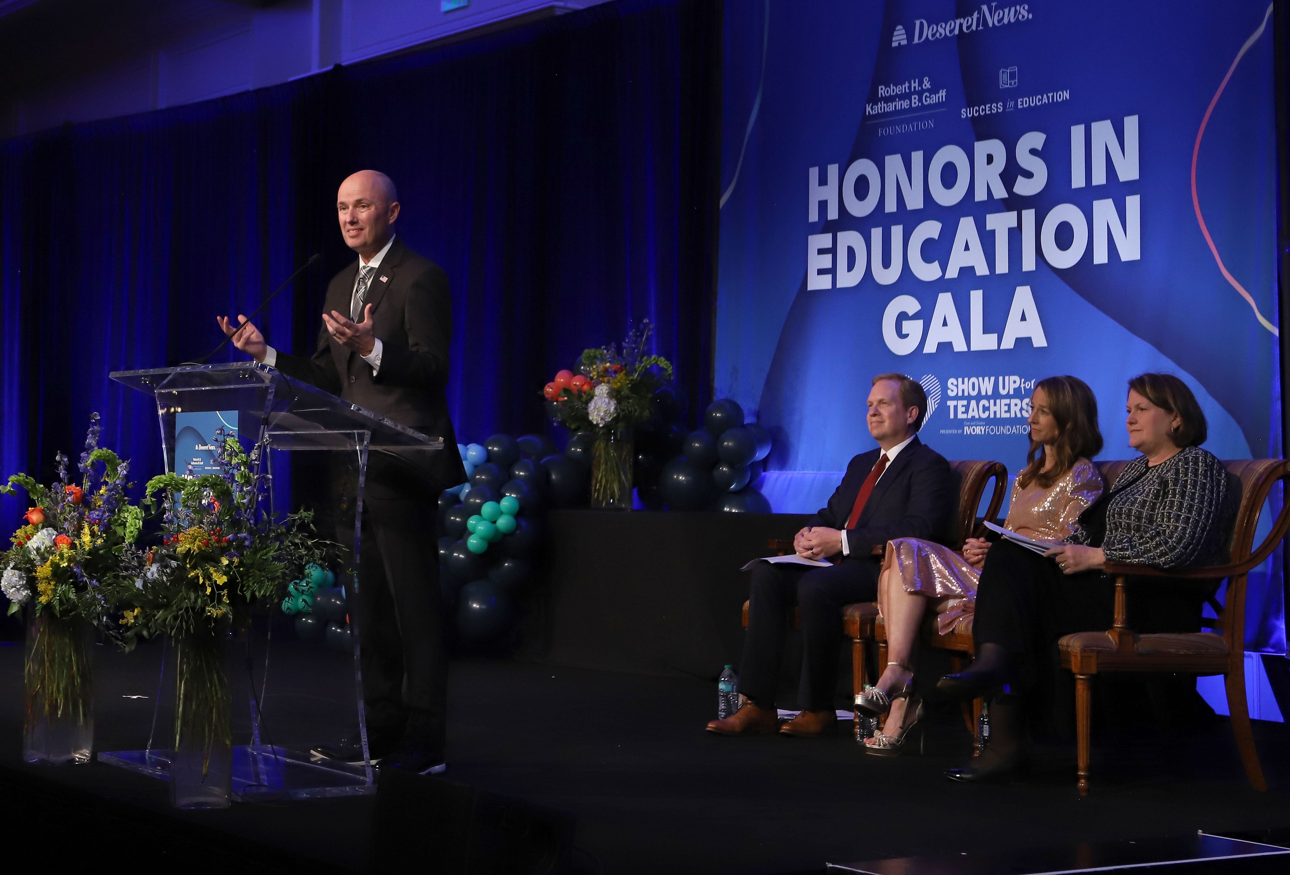 Gov. Spencer Cox speaks at an event to honor teachers Monday in Salt Lake City. Seated behind Cox are Deseret News Publisher Burke Olsen, Utah first lady Abby Cox and Deseret News Editor Sarah Jane Weaver.