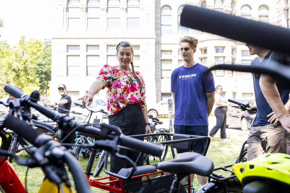 Salt Lake City Mayor Erin Mendenhall talks over e-bikes with Grant Smith, of Trek Bikes SLC, during an event where Salt Lake City announced the launch of its e-bike voucher program held at Washington Square Park in Salt Lake City on Tuesday.
