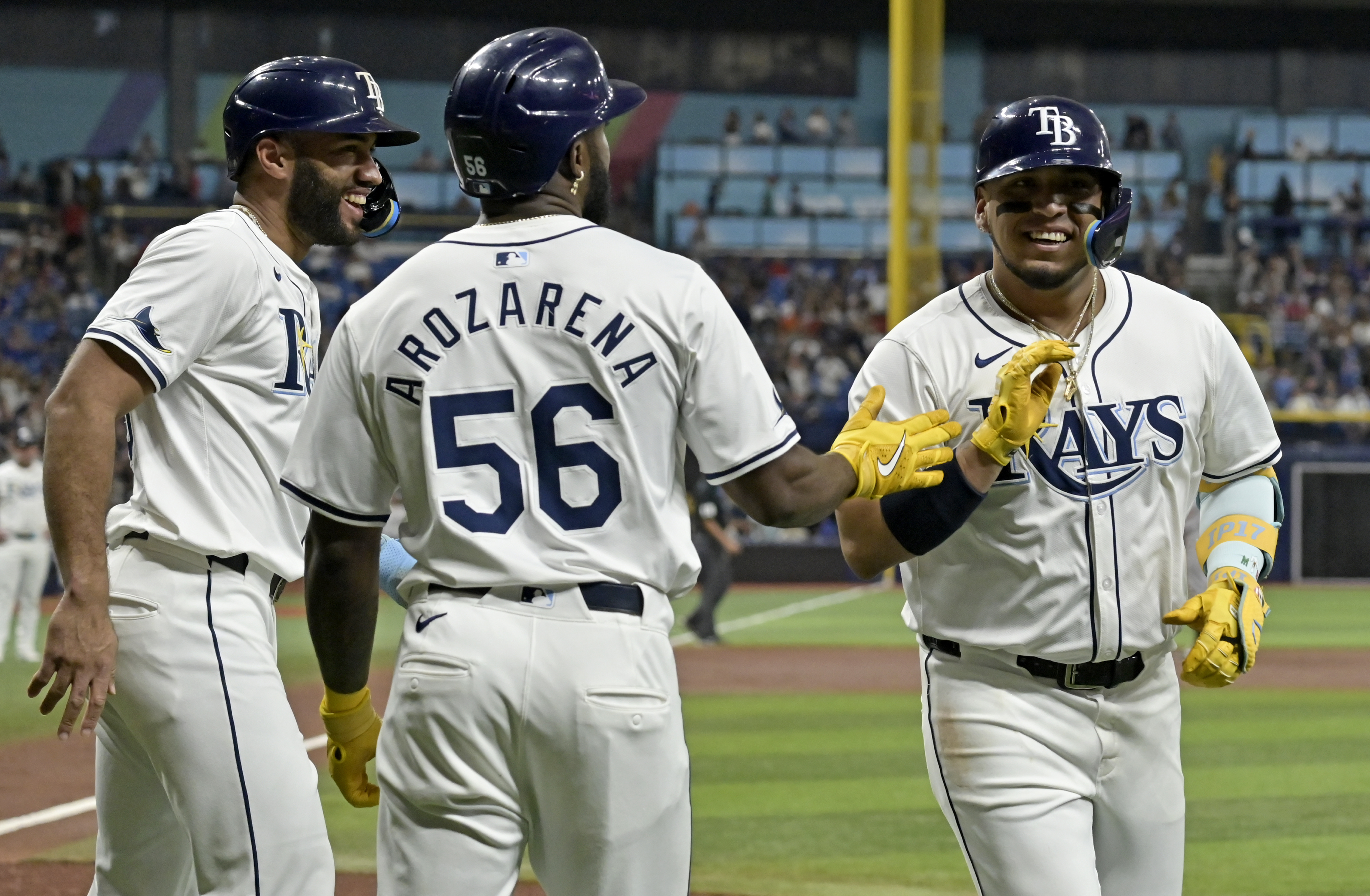 Tampa Bay Rays' Isaac Paredes, right, celebrates with Amed Rosario, left, and Randy Arozarena (56) after hitting a three-run home run off New York Yankees starter Carlos Rodón in the first inning of a baseball game Tuesday, July 9, 2024, in St. Petersburg, Fla. 
