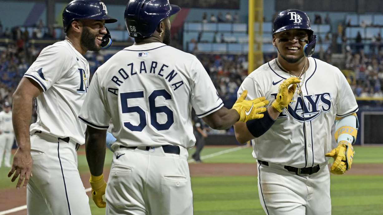 Tampa Bay Rays' Isaac Paredes, right, celebrates with Amed Rosario, left, and Randy Arozarena (56) after hitting a three-run home run off New York Yankees starter Carlos Rodón in the first inning of a baseball game Tuesday, July 9, 2024, in St. Petersburg, Fla.