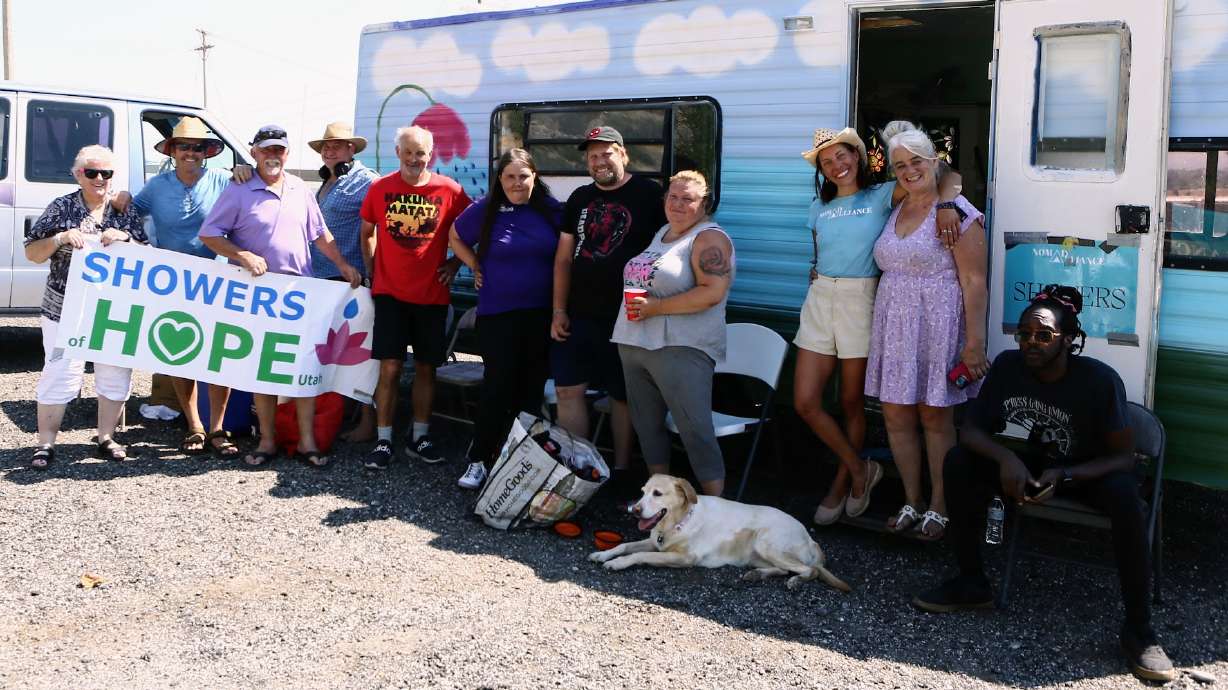Nonprofit Showers of Hope and Nomad Alliance pose for a picture outside of the first mobile shower unit in Salt Lake City on Tuesday.