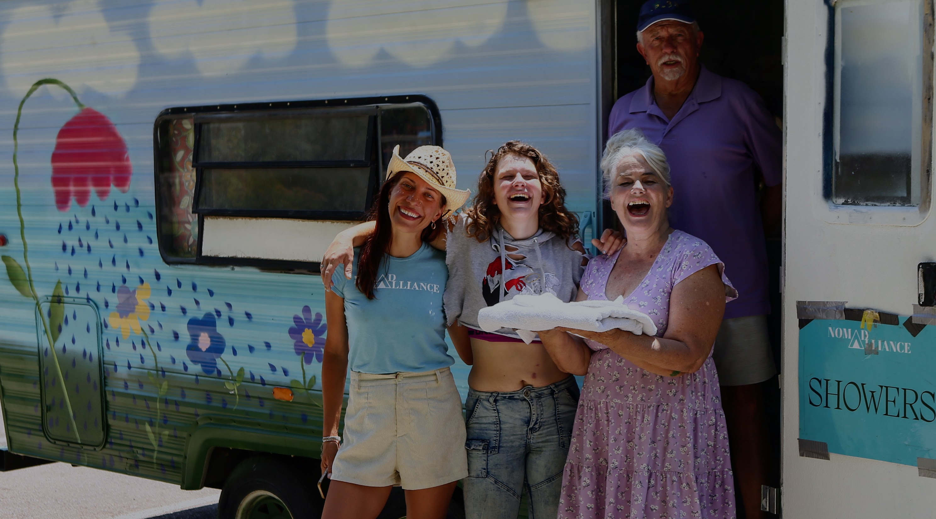 Nonprofit Open Mind's "Showers of Hope" and Nomad Alliance pose for a picture along with Alabama Liberty, whose experiencing homelessness, outside of the first mobile shower in Salt Lake City on July 9, 2024.