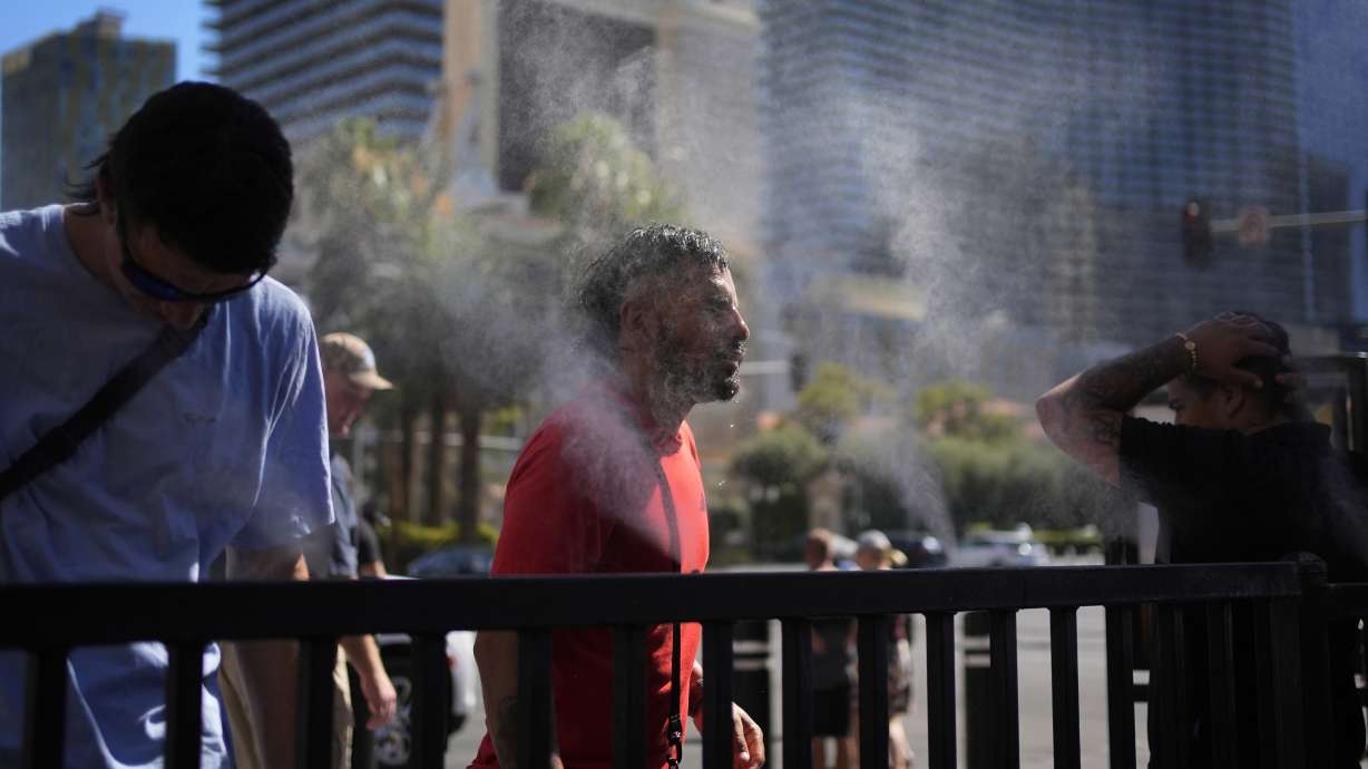 People cool off in misters along the Las Vegas Strip, Sunday in Las Vegas. Residents are now eyeing the thermometer as the desert city is on track Wednesday to set a record for the most consecutive days over 115 degrees.