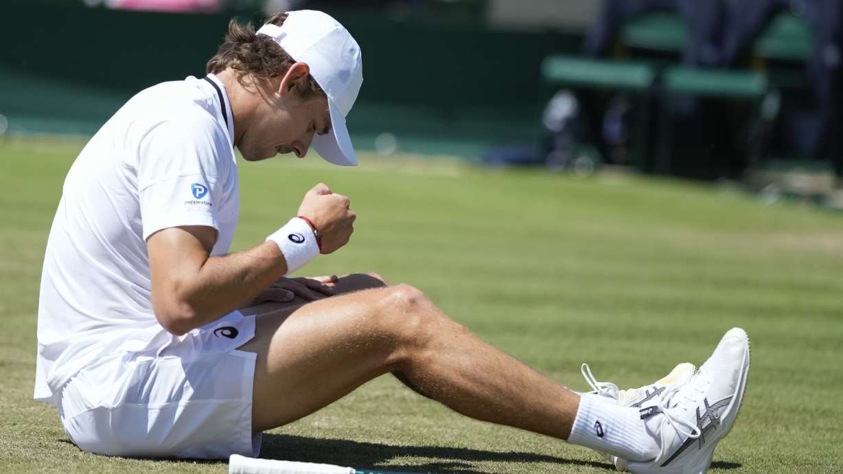 Alex de Minaur of Australia sits on the grass after a fall during his second round match against Jaume Munar of Spain at the Wimbledon tennis championships in London, Thursday, July 4, 2024.