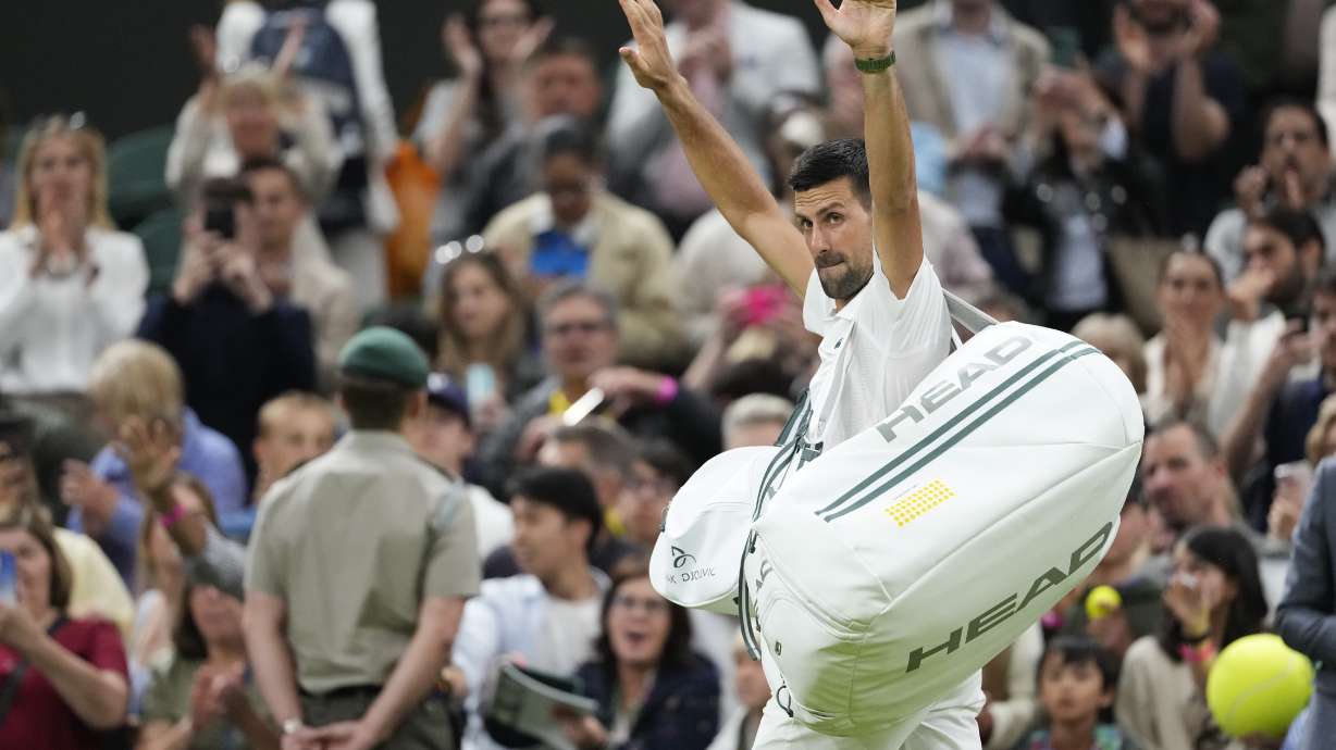 Novak Djokovic of Serbia waves as he leaves the court after defeating Holger Rune of Denmark in their fourth round match at the Wimbledon tennis championships in London, Monday, July 8, 2024.
