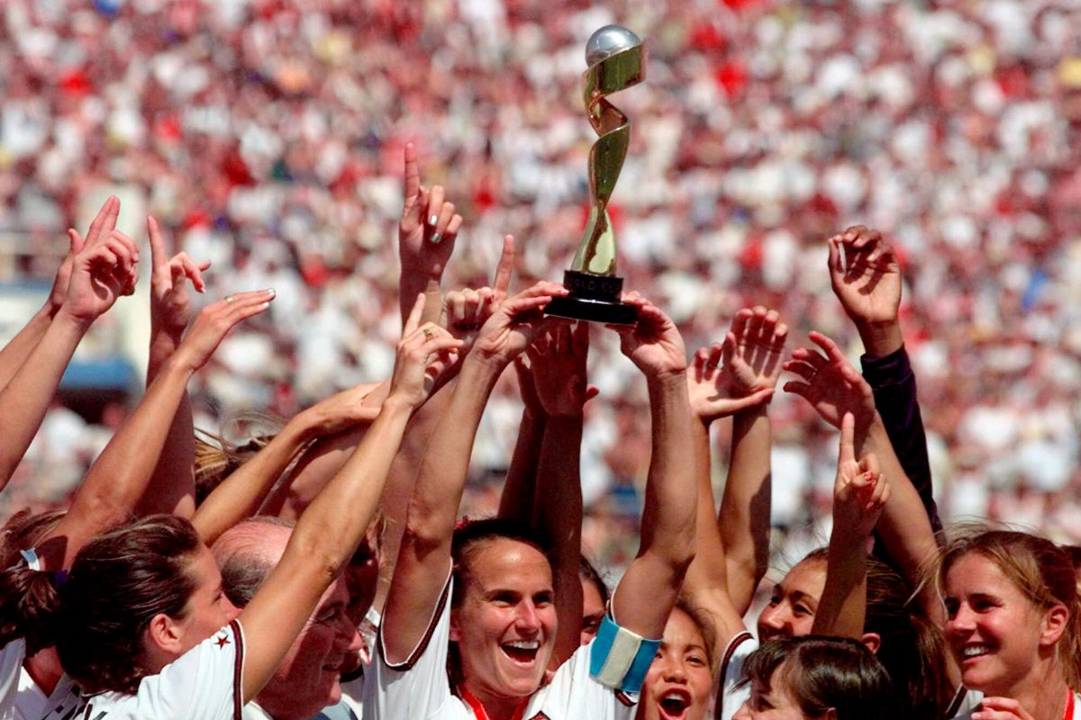 United States soccer team captain Carla Overbeck, center, the U.S. team and FIFA President Sepp Blatter, left, of Overbeck, celebrate with the trophy after defeating China in a 5-4 in a penalty shootout in the Women's World Cup final soccer match at the Rose Bowl in Pasadena, Calif., July 10, 1999. Players on the team paved the way for better pay and equitable treatment for women.