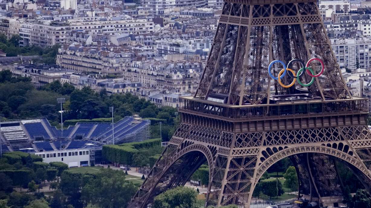 The Olympic rings are seen on the Eiffel Tower in Paris, France, Monday, June 17, 2024. The Champ-de-Mars at left will host the Beach Volleyball and Blind Football at the Paris 2024 Olympic and Paralympic Games.