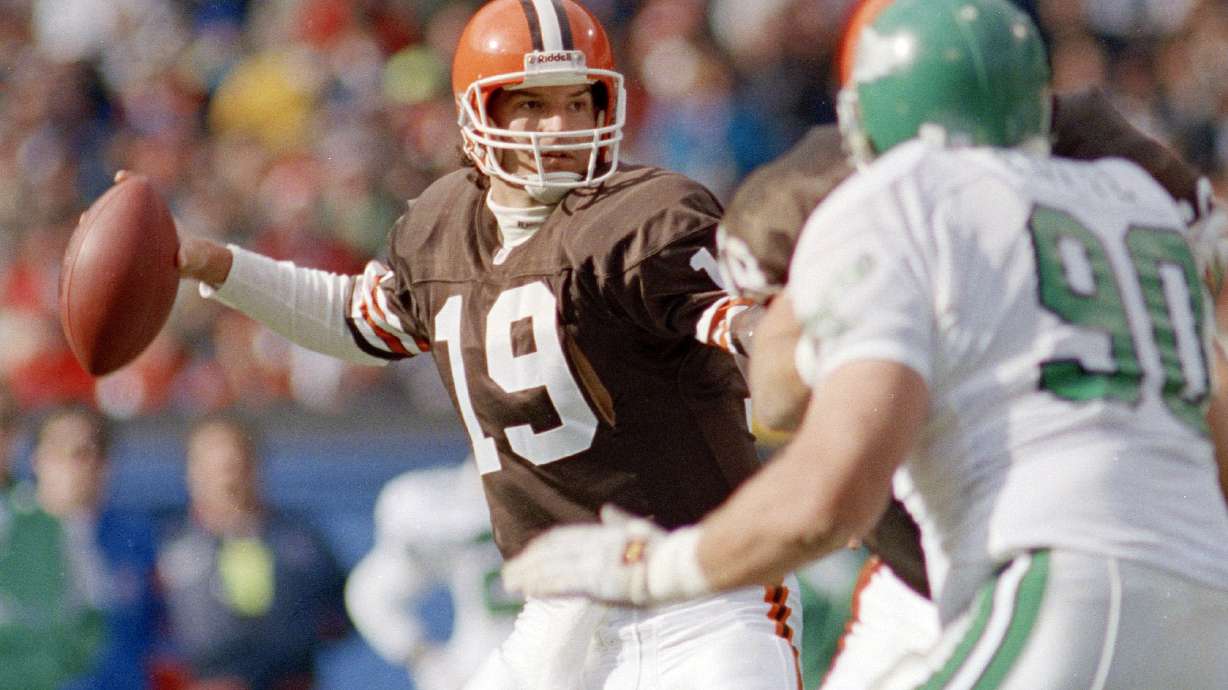 FILE - Cleveland Brown's quarterback Bernie Kosar (19) winds up to throw in the first quarter as Philadelphia Eagles defensive tackle Mike Golic (90) rushes during an NFL football game in Cleveland, Nov. 10, 1991. The former Browns great is in “the fight of his life” dealing with liver failure and the early stages of Parkinson’s disease, Cleveland Magazine reports.