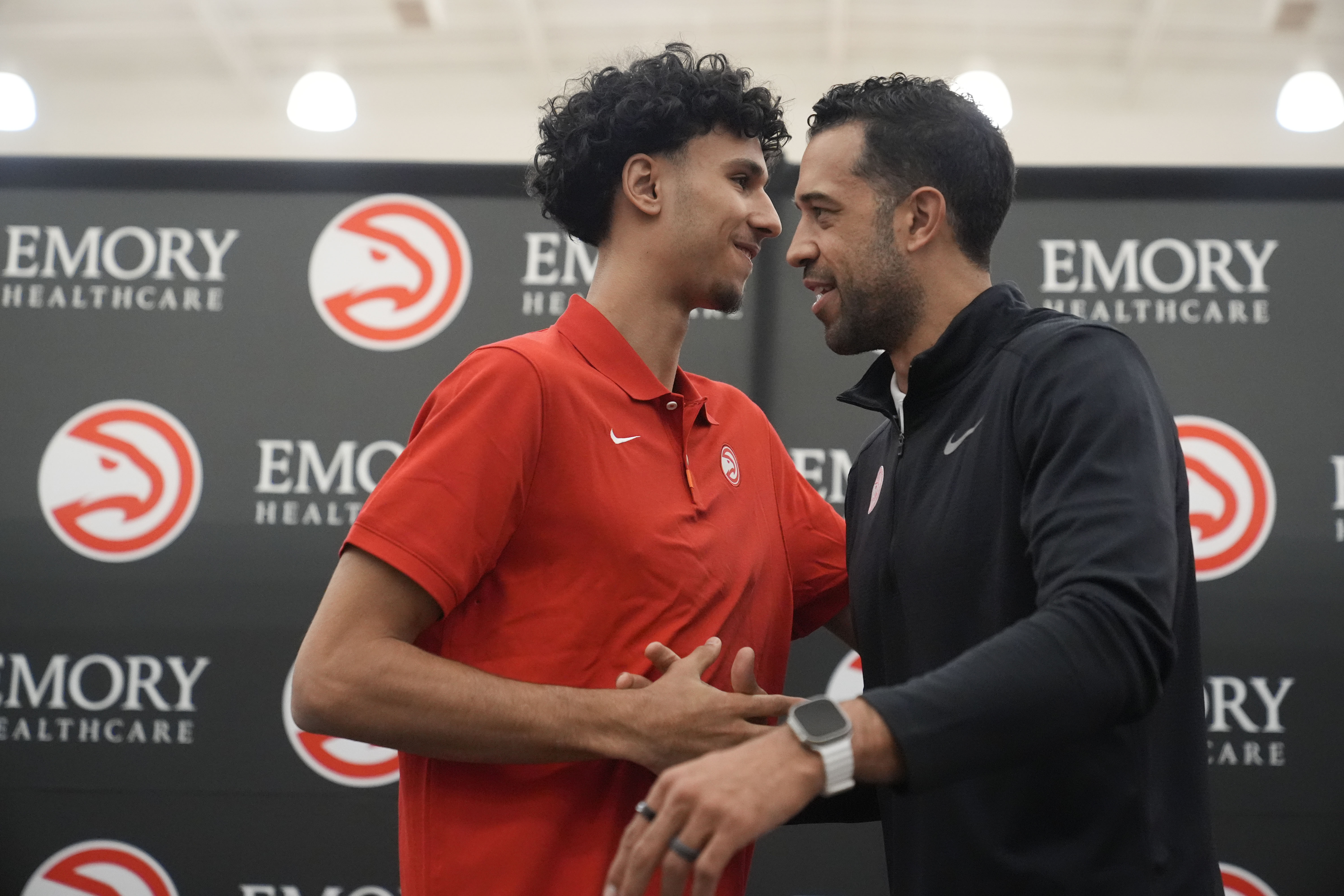 Atlanta Hawks' Zaccharie Risacher, left, and General Manager Landry Fields talk after an NBA basketball news conference, Friday, June 28, 2024, in Atlanta. Risacher was selected as the first overall pick by the Atlanta Hawks in the first round of the NBA basketball draft. 