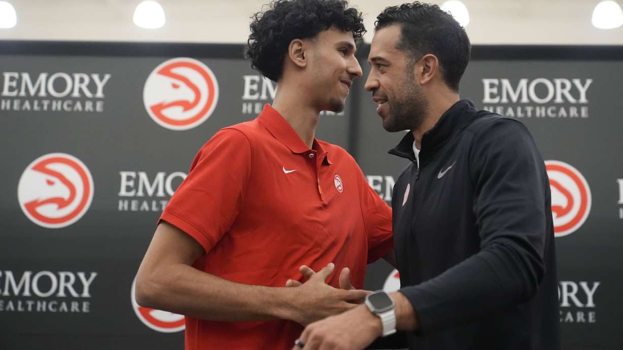 Atlanta Hawks' Zaccharie Risacher, left, and General Manager Landry Fields talk after an NBA basketball news conference, Friday, June 28, 2024, in Atlanta. Risacher was selected as the first overall pick by the Atlanta Hawks in the first round of the NBA basketball draft.