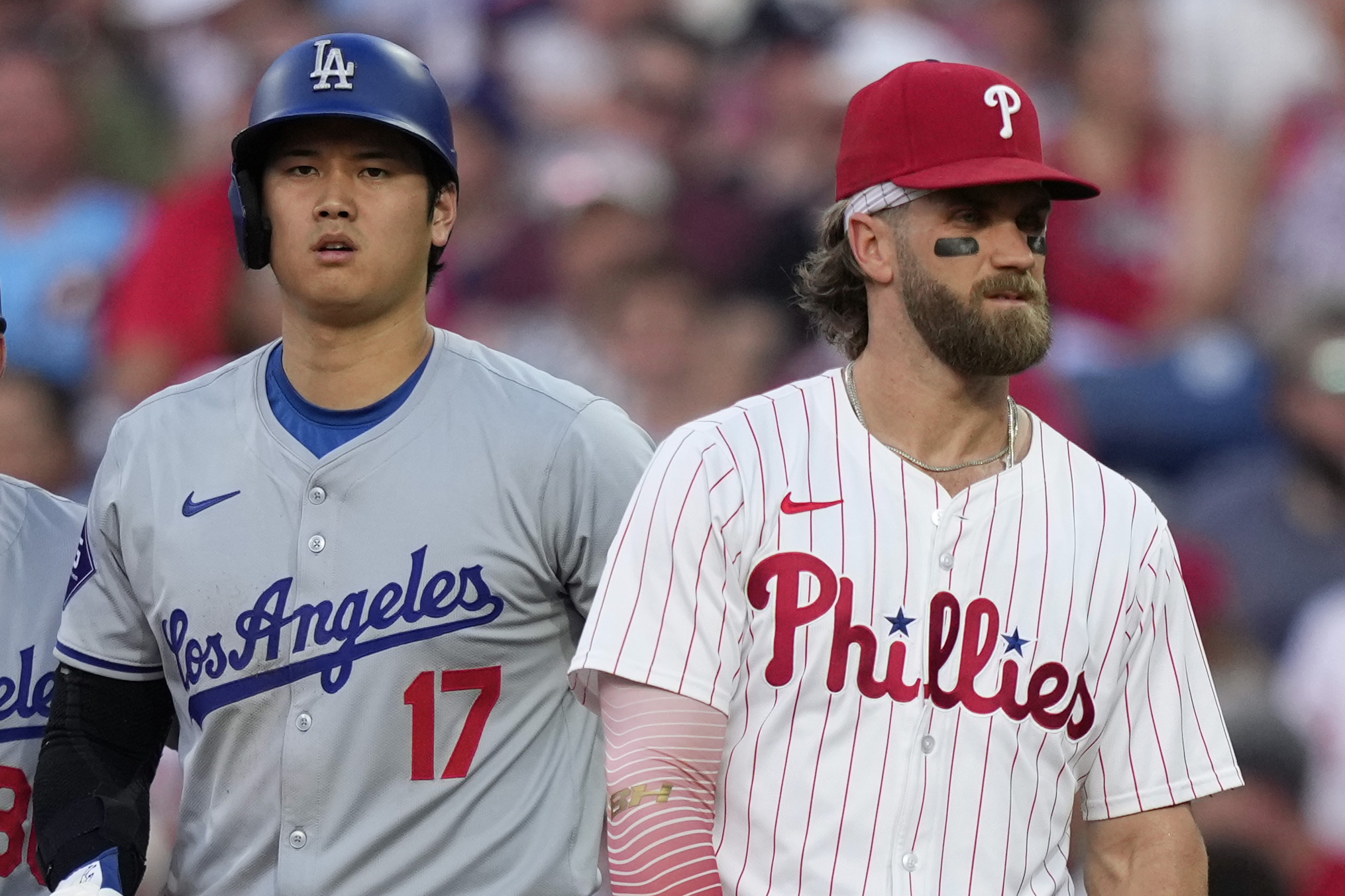 Los Angeles Dodgers' Shohei Ohtani, left, and Philadelphia Phillies' Bryce Harper stand near first base during the third inning of a baseball game, Tuesday, July 9, 2024, in Philadelphia. 