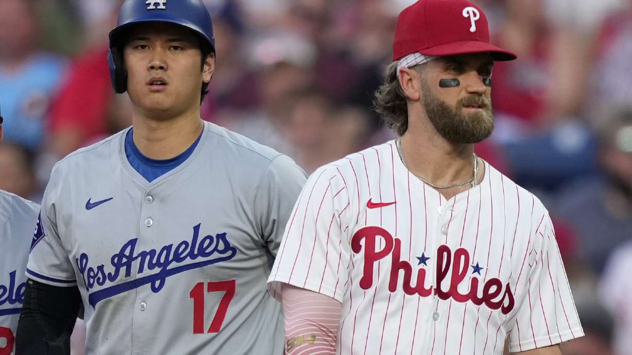Los Angeles Dodgers' Shohei Ohtani, left, and Philadelphia Phillies' Bryce Harper stand near first base during the third inning of a baseball game, Tuesday, July 9, 2024, in Philadelphia.