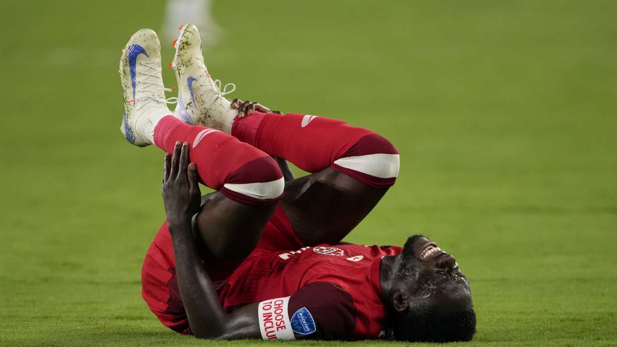 Canada's Alphonso Davies grimaces in pain during a Copa America semifinal soccer match against Argentina in East Rutherford, N.J., Tuesday, July 9, 2024.