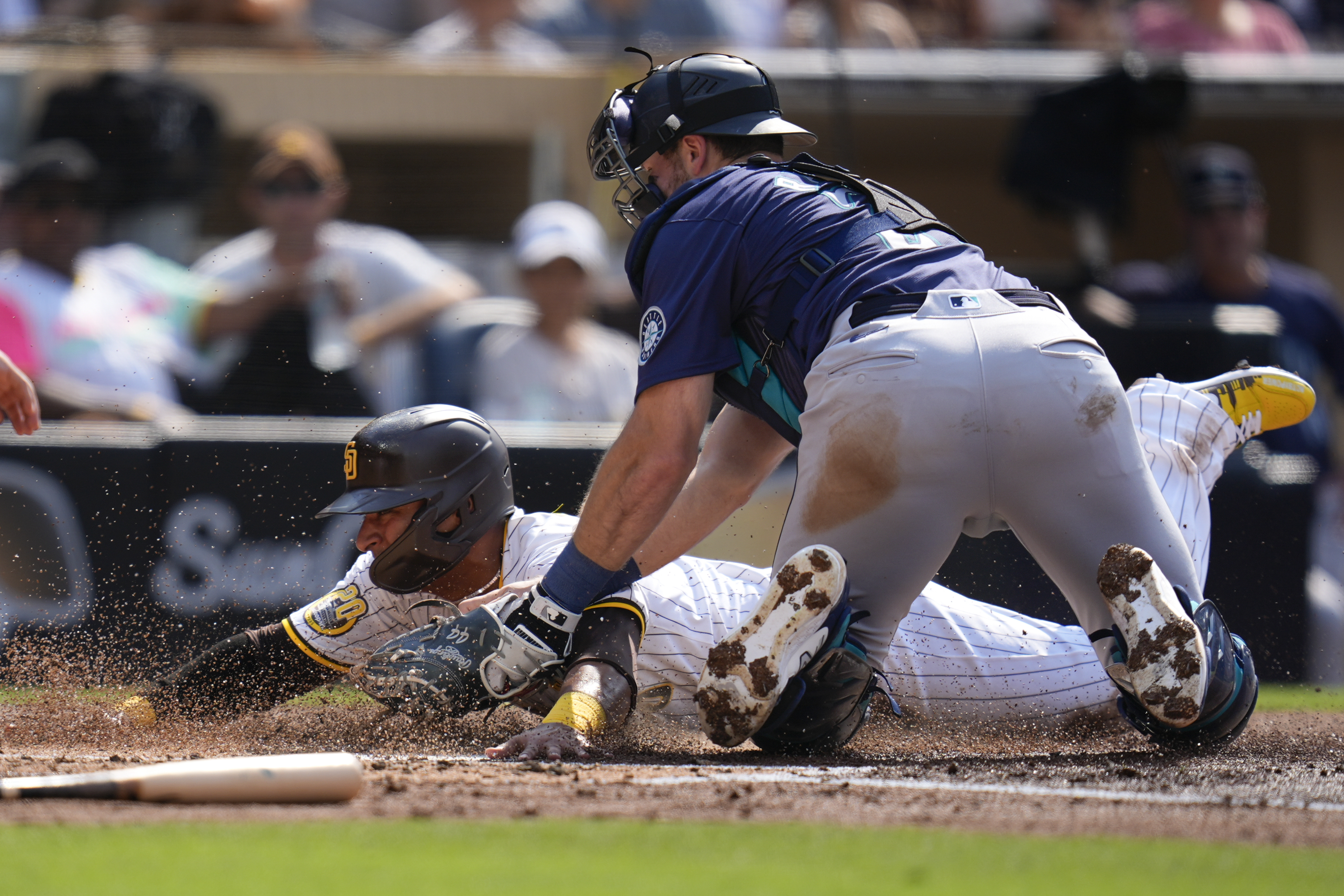 San Diego Padres' Donovan Solano, left, is tagged out at home by Seattle Mariners catcher Cal Raleigh during the second inning of a baseball game Wednesday, July 10, 2024, in San Diego. 
