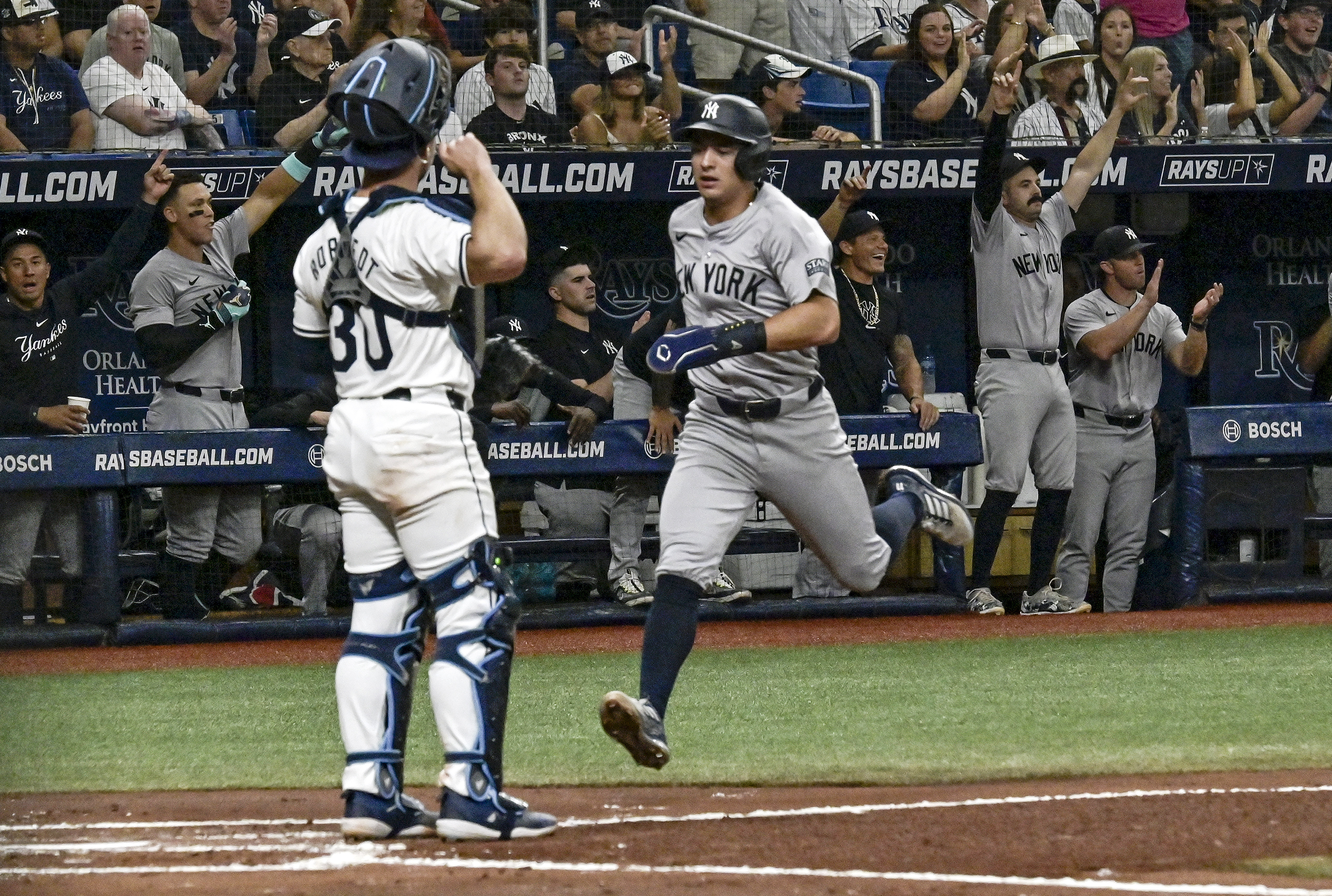 Tampa Bay Rays catcher Ben Rortvedt (30) looks on as New York Yankees' Anthony Volpe scores on Trent Grisham's RBI double during the second inning of a baseball game Wednesday, July 10, 2024, in St. Petersburg, Fla. 