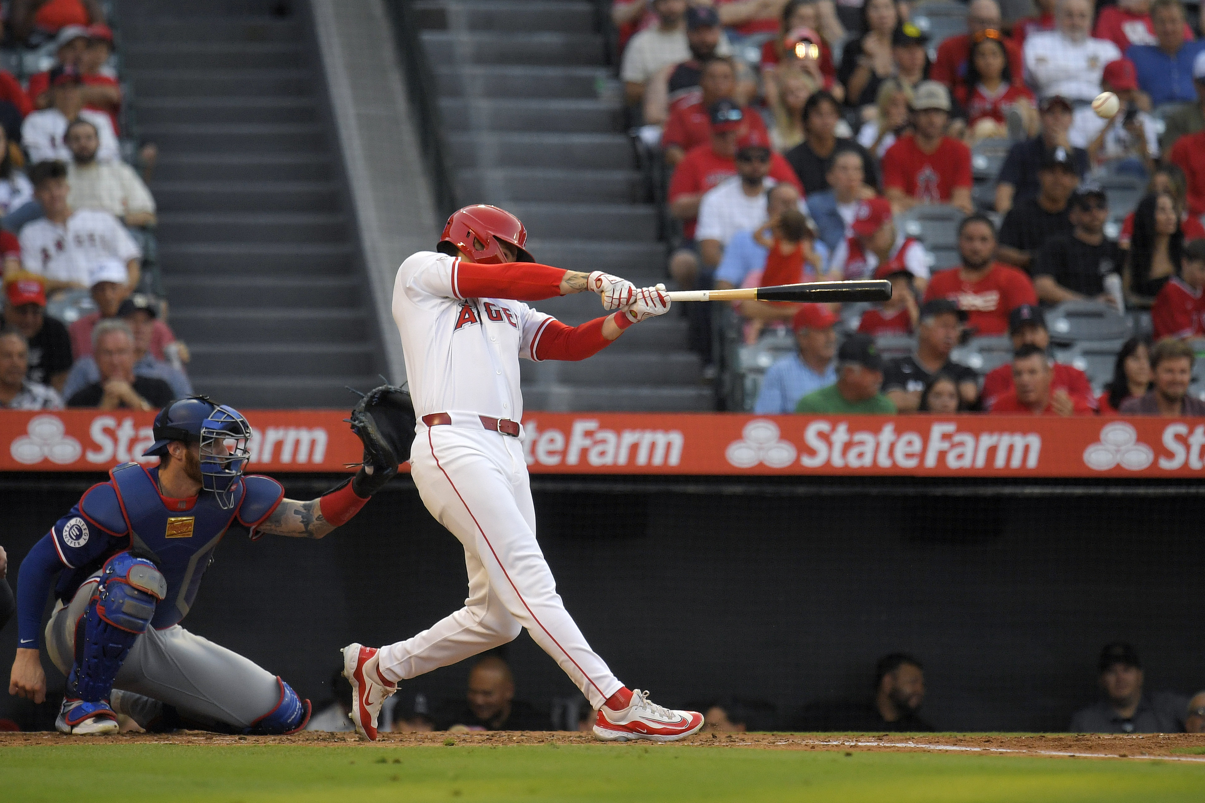 Los Angeles Angels' Mickey Moniak, right, hits a three-run home run as Texas Rangers catcher Jonah Heim watches during the second inning of a baseball game Wednesday, July 10, 2024, in Anaheim, Calif. 