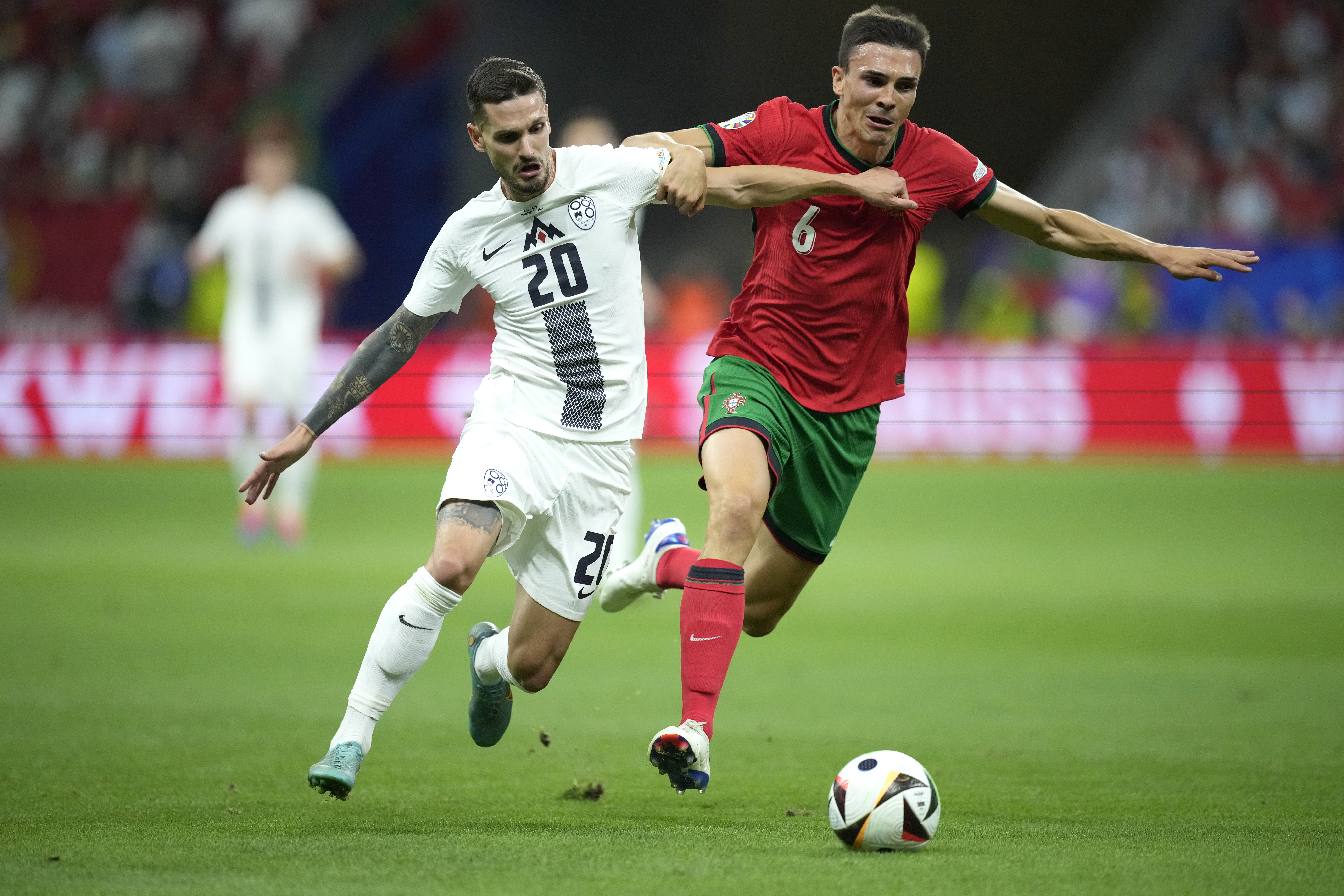 Portugal's Joao Palhinha, right, challenges for the ball with Slovenia's Petar Stojanovic during a round of sixteen match between Portugal and Slovenia at the Euro 2024 soccer tournament in Frankfurt, Germany, Monday, July 1, 2024.