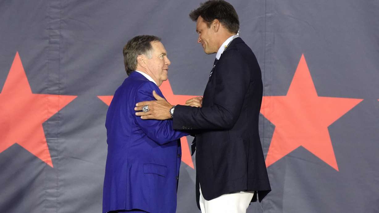 Former New England Patriots quarterback Tom Brady, right, greets former Patriots head coach Bill Belichick, left, on stage during Patriots Hall of Fame induction ceremonies for Brady at Gillette Stadium, Wednesday, June 12, 2024, in Foxborough, Mass.