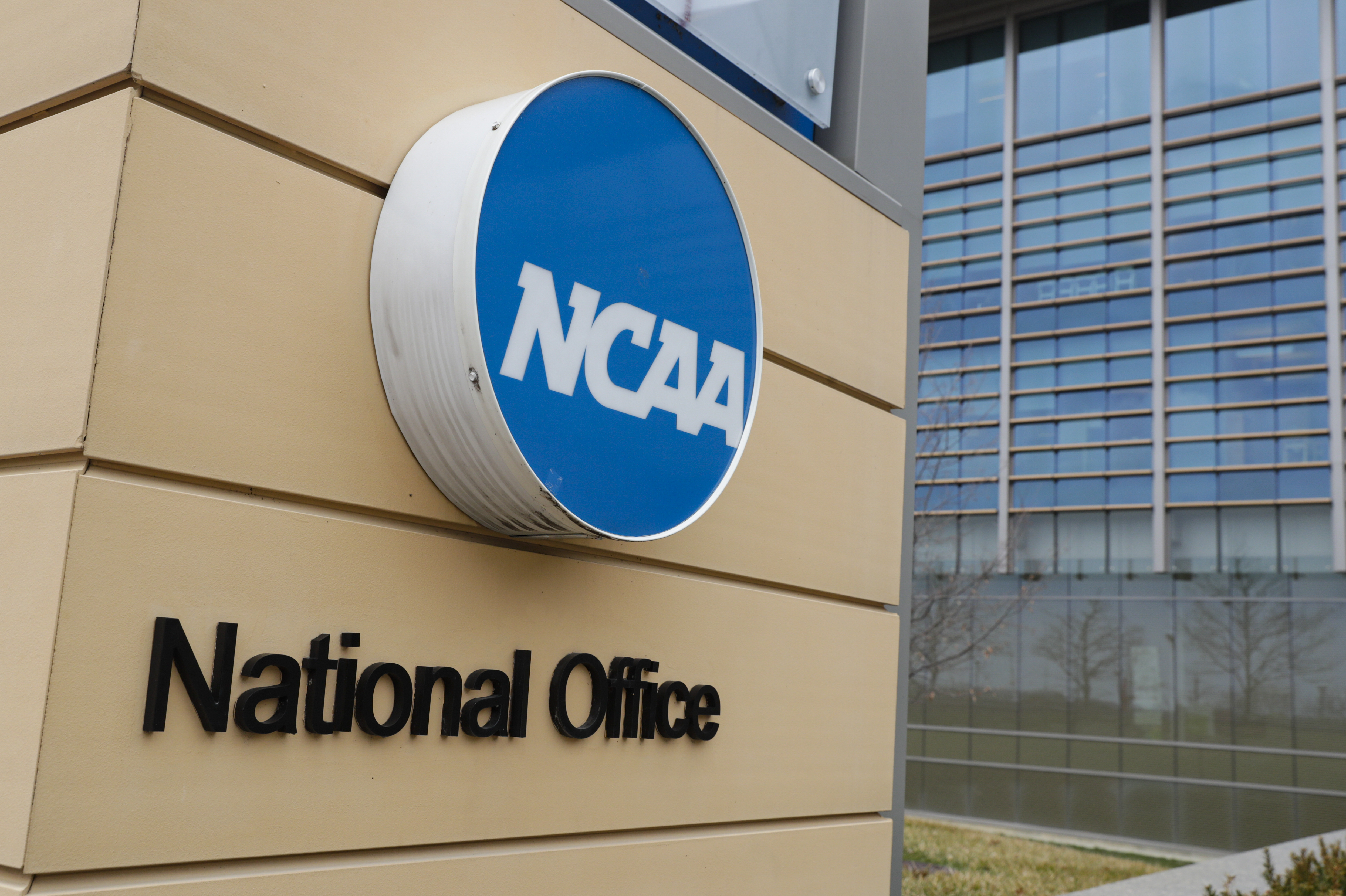 FILE - Signage at the headquarters of the NCAA is viewed in Indianapolis, March 12, 2020. A U.S. appeals court in Philadelphia has ruled that some college athletes may qualify as employees under federal wage-and-hour laws. The court says a test should be developed to differentiate students who play college sports for fun from those whose effort “crosses the legal line into work” that benefits the school. The NCAA had hoped to have the case dismissed.