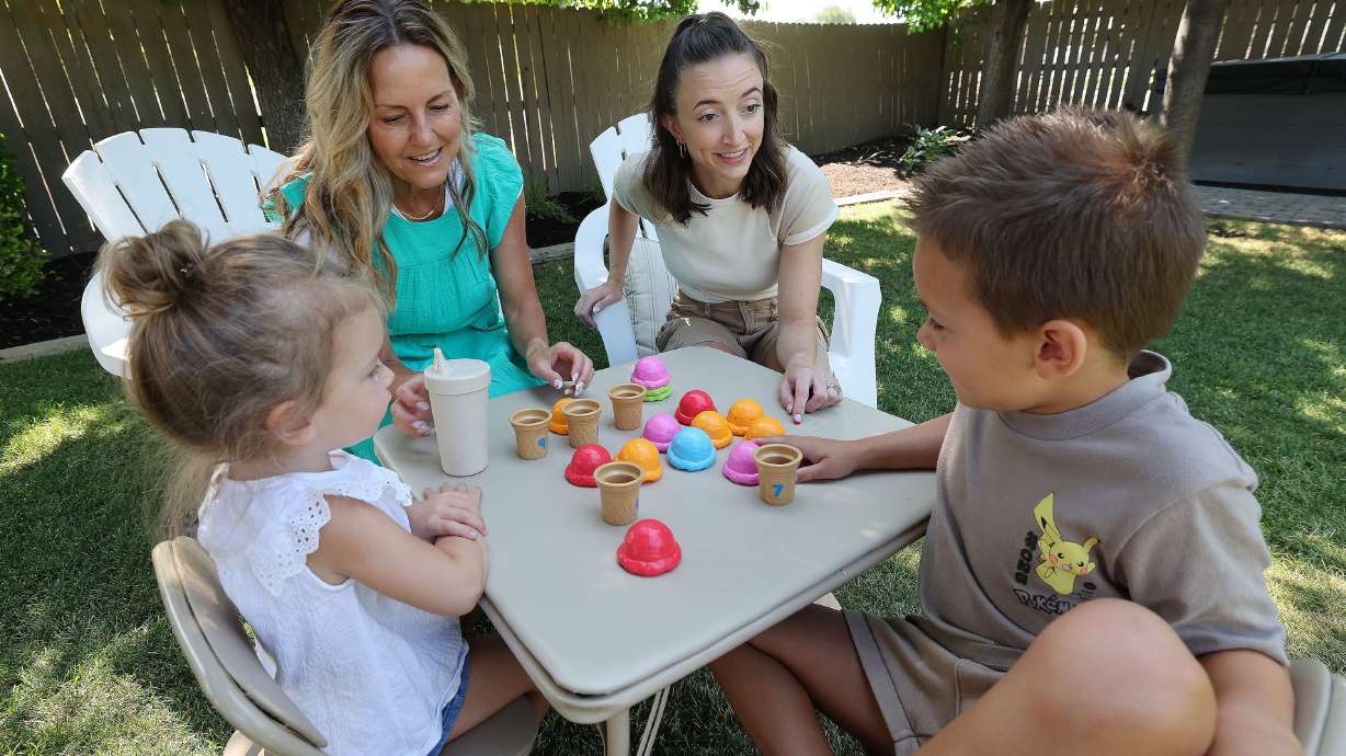 Kris Piggott, her daughter, Lauren Naylor, and grandkids, Wells, 6, and Arden, 3, play in the yard in Provo on Thursday. Most parents are willing to go into debt for the sake of their child's social life, a study finds.