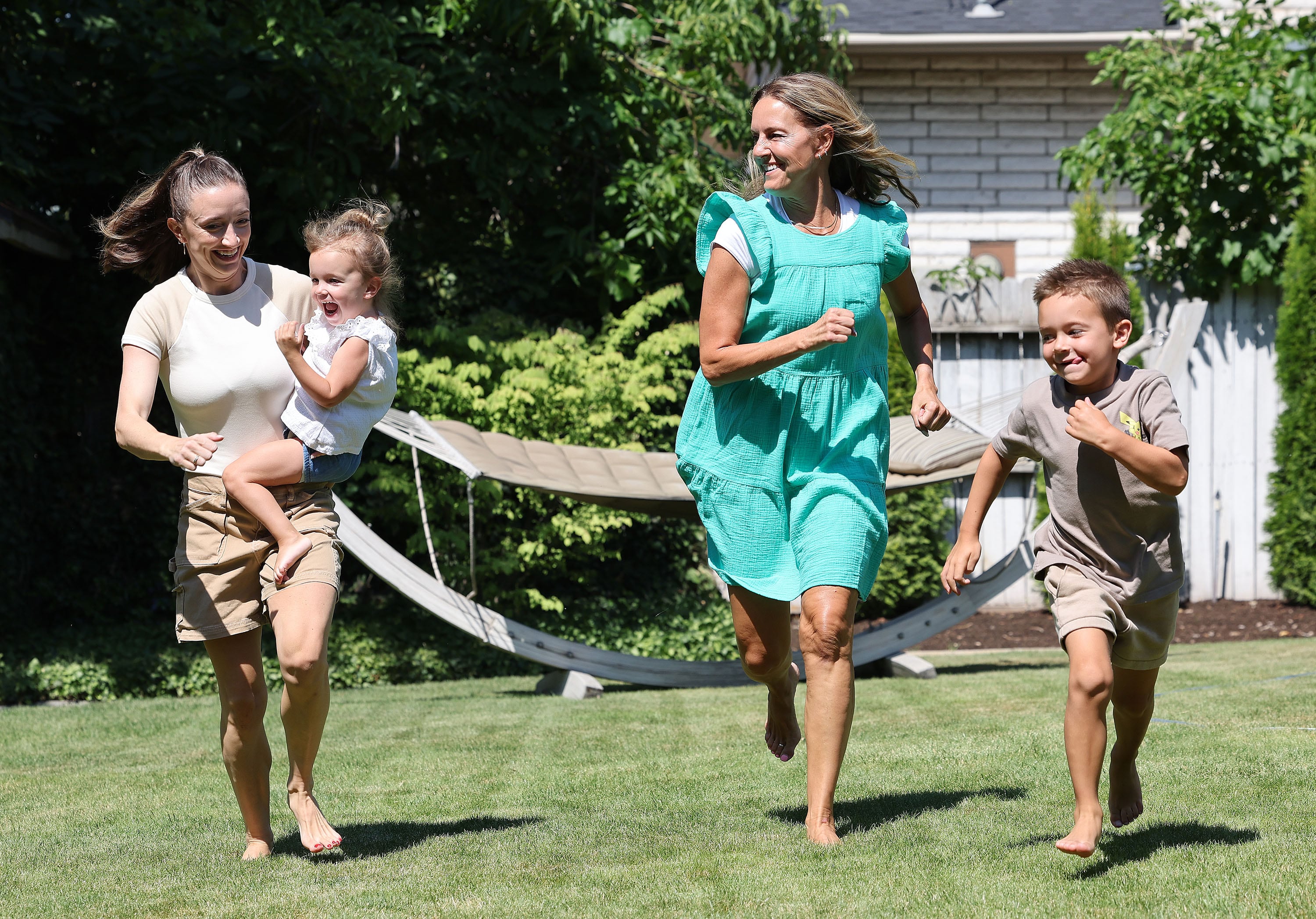 Kris Piggott, her daughter, Lauren Naylor, and grandkids, Wells, 6, and Arden, 3, play in the yard in Provo on Thursday.