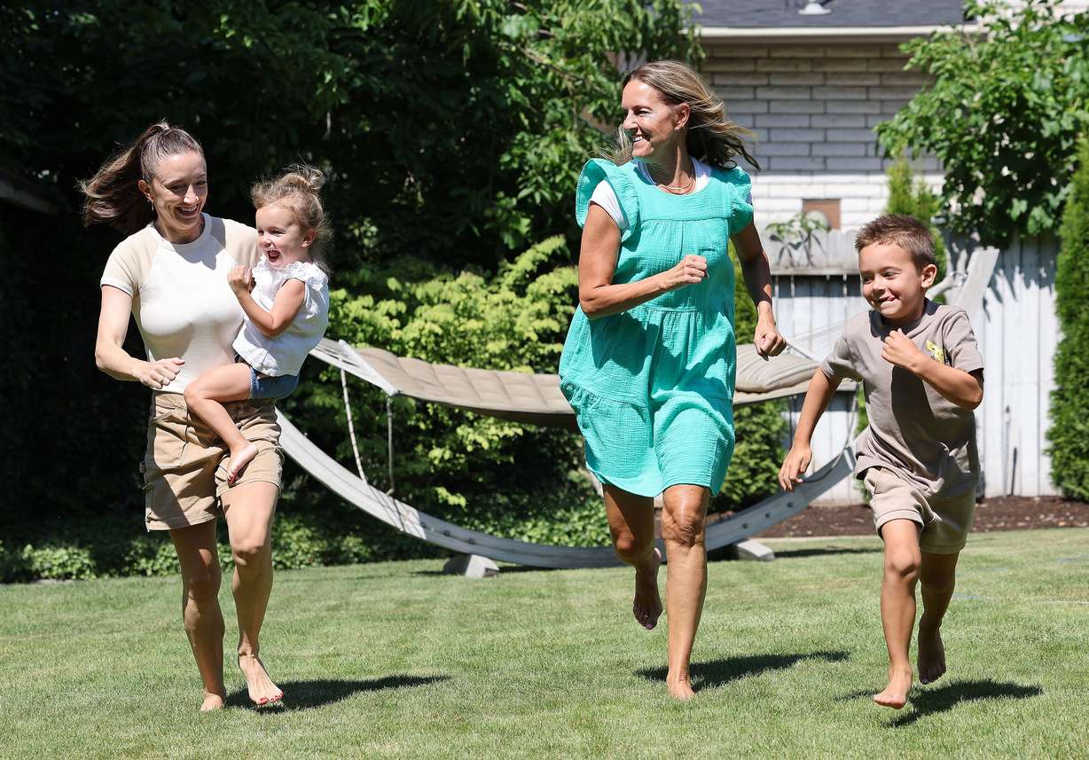 Kris Piggott, her daughter, Lauren Naylor, and grandkids, Wells, 6, and Arden, 3, play in the yard in Provo on Thursday.