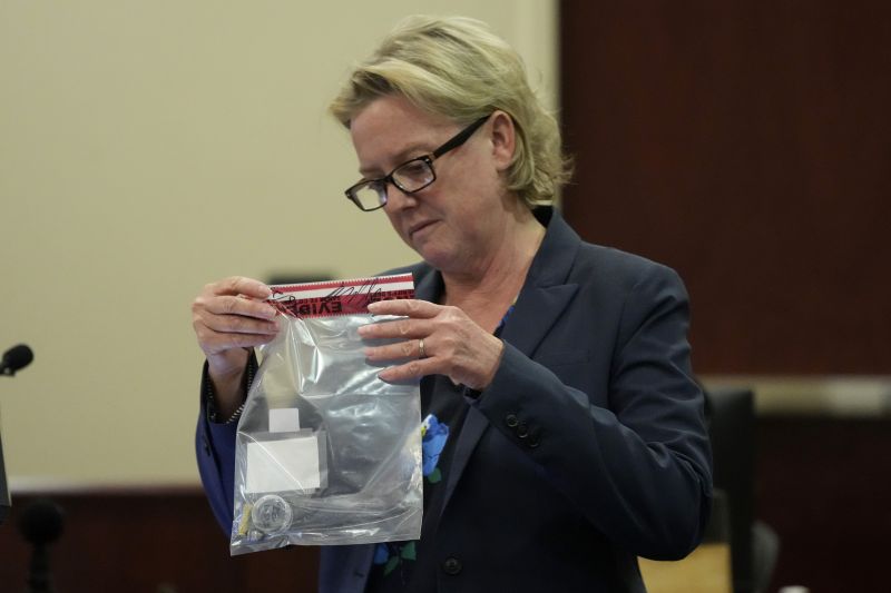 Special prosecutor Kari Morrissey holds an evidence bag with a bullet in it during actor Alec Baldwin's hearing in Santa Fe County District Court, Wednesday, in Santa Fe, N.M.