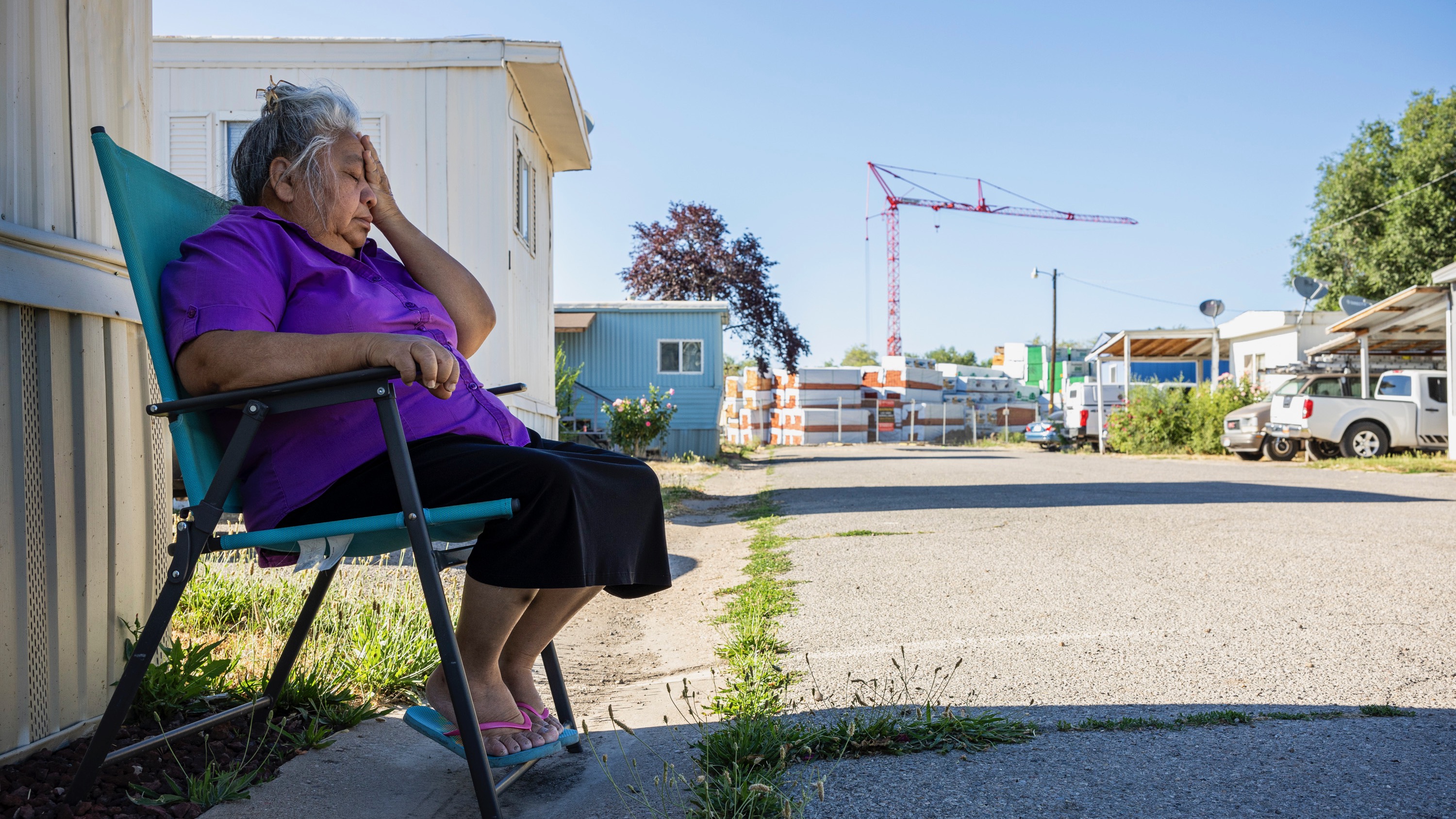 Vilma Puente wipes her face as she relaxes in the shade of a home at the Cedarwood Mobile Home Park in Layton on July 2.