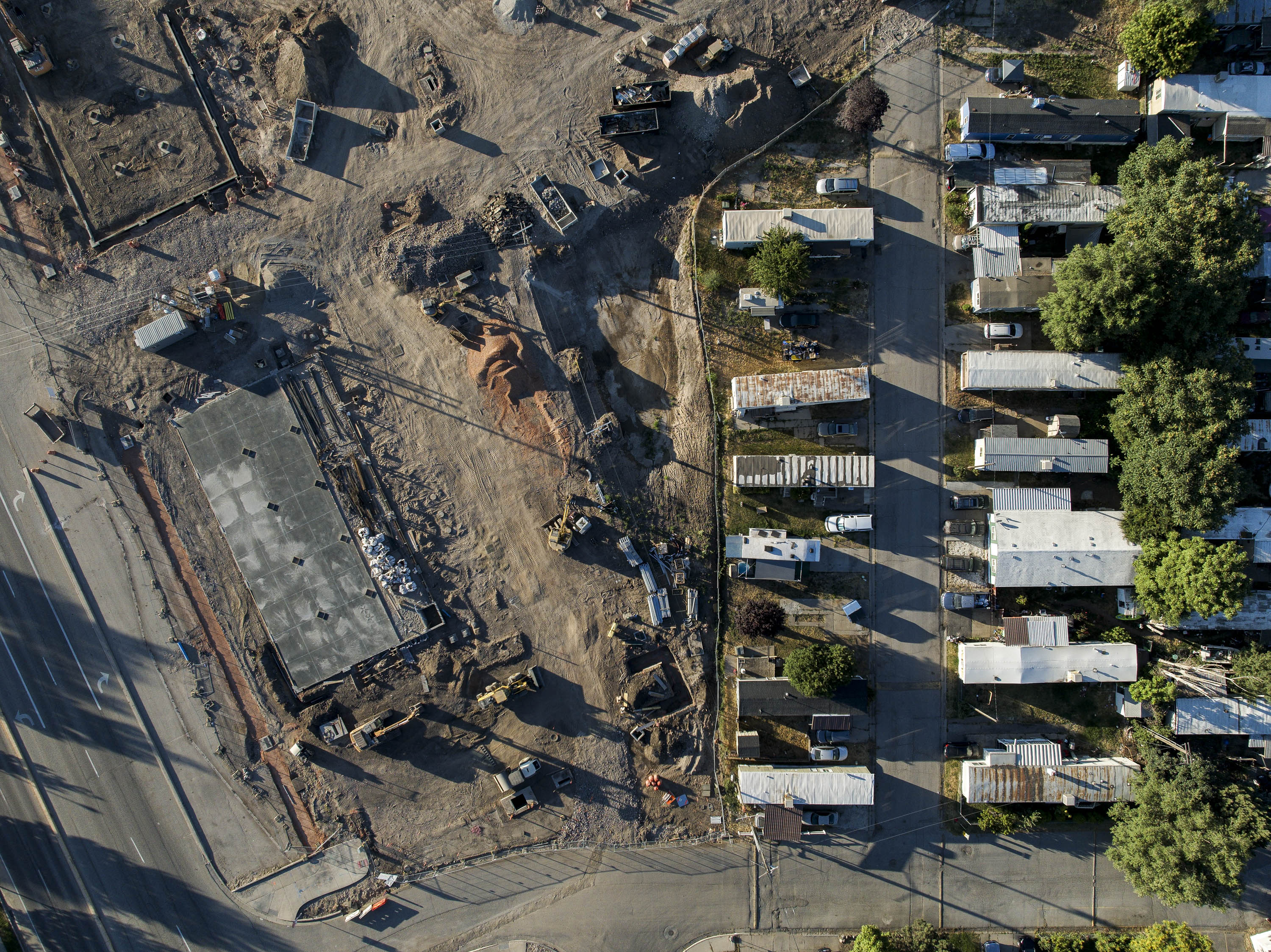 Homes stand next to a construction site at the Cedarwood Mobile Home Park in Layton on July 2.