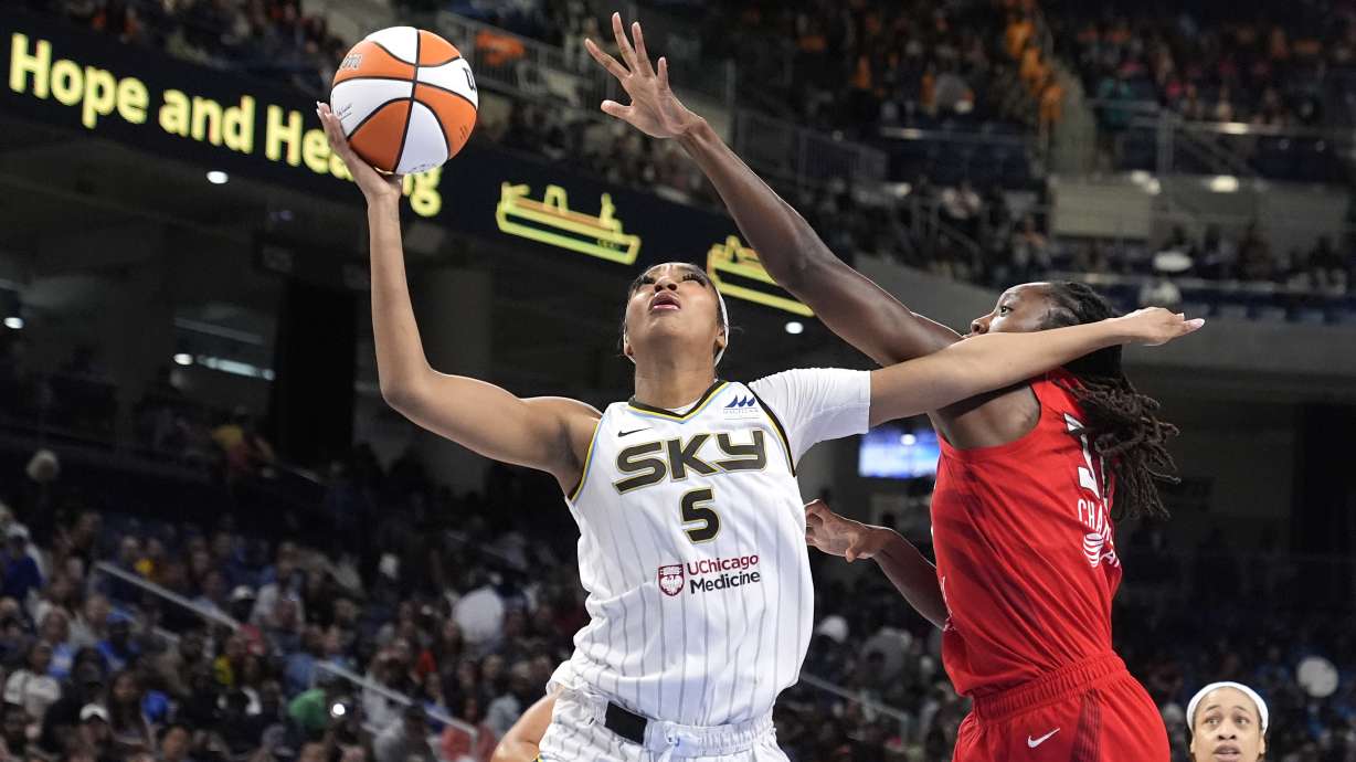 Chicago Sky's Angel Reese (5) shoots past the out stretch arm of Atlanta Dream's Tina Charles during the second half of a WNBA basketball game Wednesday, July 10, 2024, in Chicago. The Sky won 78-69.
