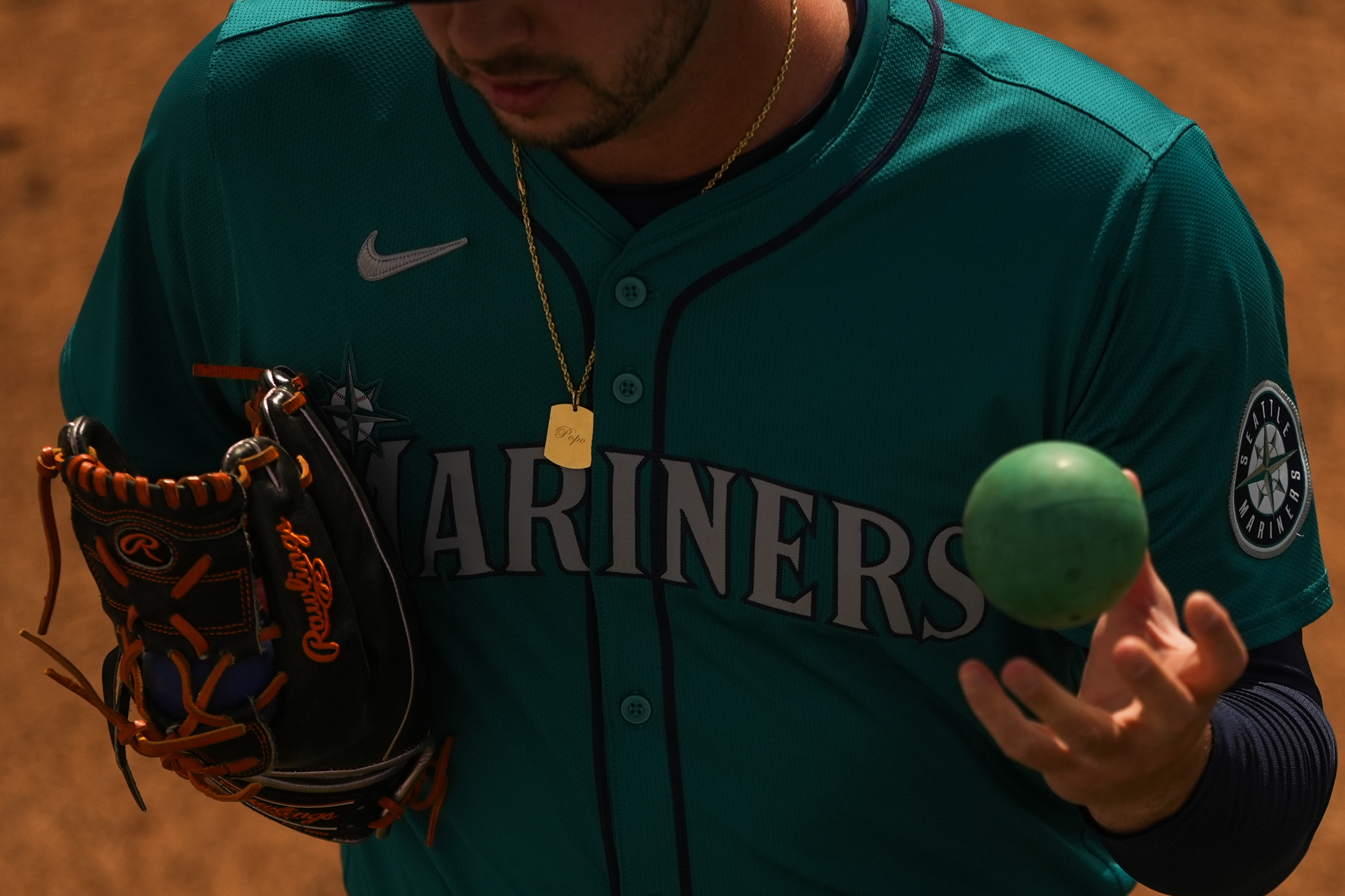 FILE - Seattle Mariners relief pitcher Tayler Saucedo uses a weighted ball to warm up in the bullpen before a spring training baseball game against the Kansas City Royals, March 6, 2024, in Surprise, Ariz. Velocity training is the rage in baseball from the youth levels up through the majors. Players go through specialized programs – often using series of progressively weighted baseballs – in the hopes of speeding up their bodies and arms, pushing them to the limits of what might be possible for their age and ability. 