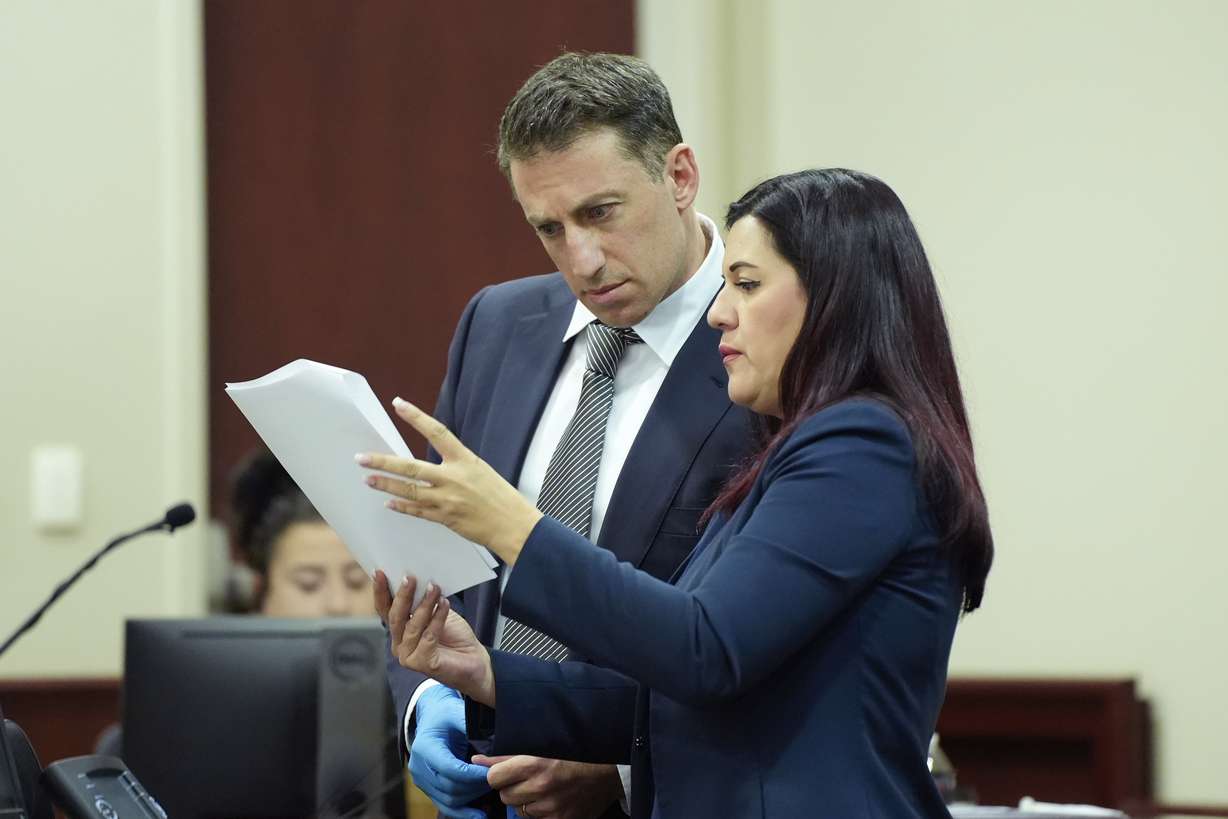 From left, Alex Spiro and Heather LeBlanc, attorneys for actor Alec Baldwin, look over paperwork during Baldwin's trial for involuntary manslaughter for the 2021 fatal shooting of cinematographer Halyna Hutchins during filming of the Western movie "Rust," Friday, at Santa Fe County District Court in Santa Fe, N.M.
