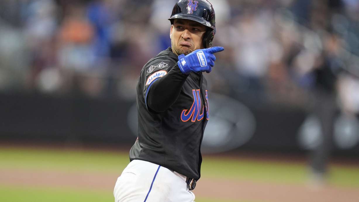 New York Mets' Jose Iglesias gestures to teammates as he runs the bases after hitting a home run during the second inning of a baseball game against the Colorado Rockies, Friday, July 12, 2024, in New York.