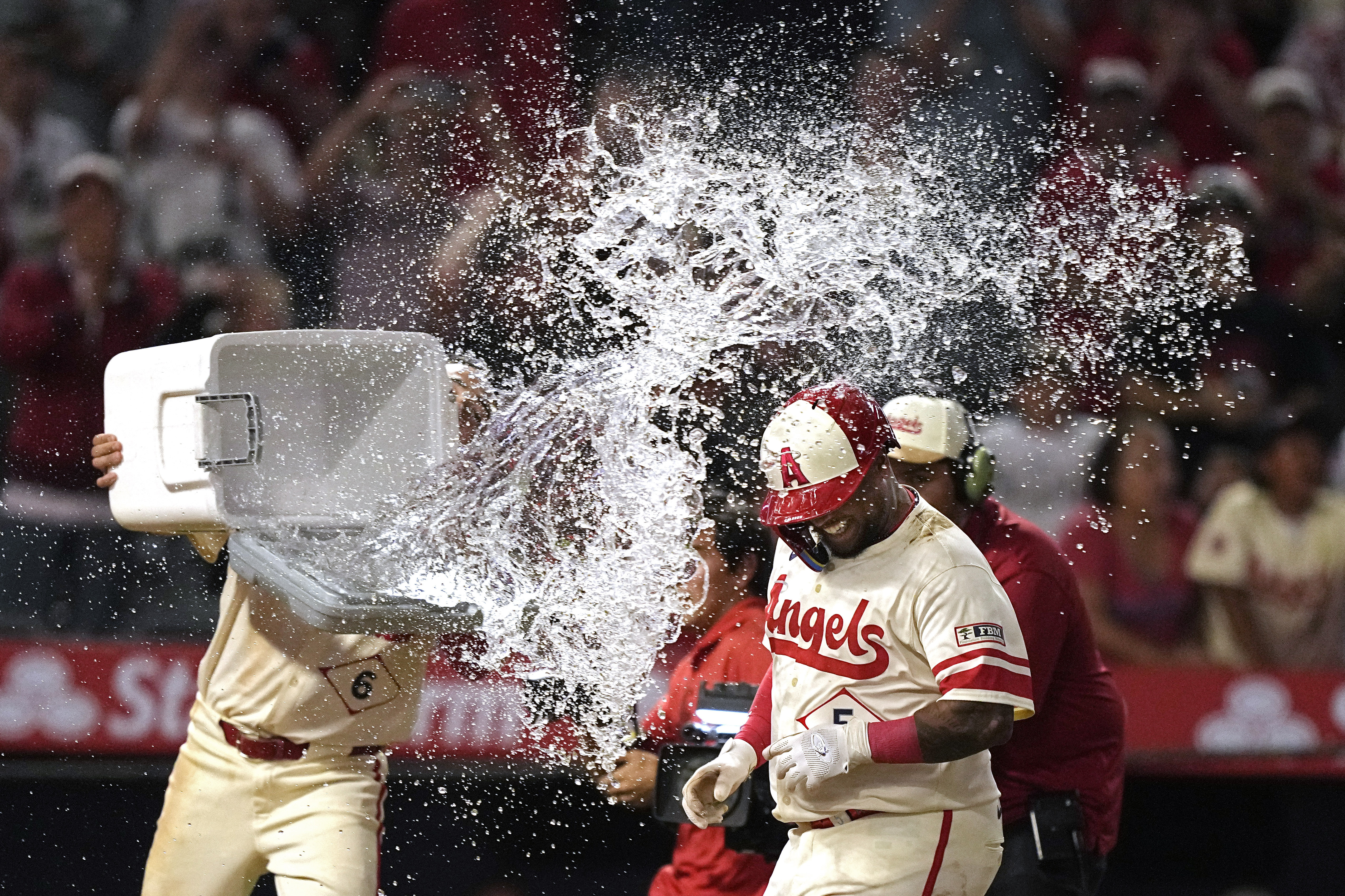 Los Angeles Angels' Willie Calhoun, is hit with water by Anthony Rendon as he scores after hitting a walk-off two-run home run during the 10th inning of a baseball game against the Seattle Mariners Friday, July 12, 2024, in Anaheim, Calif. 