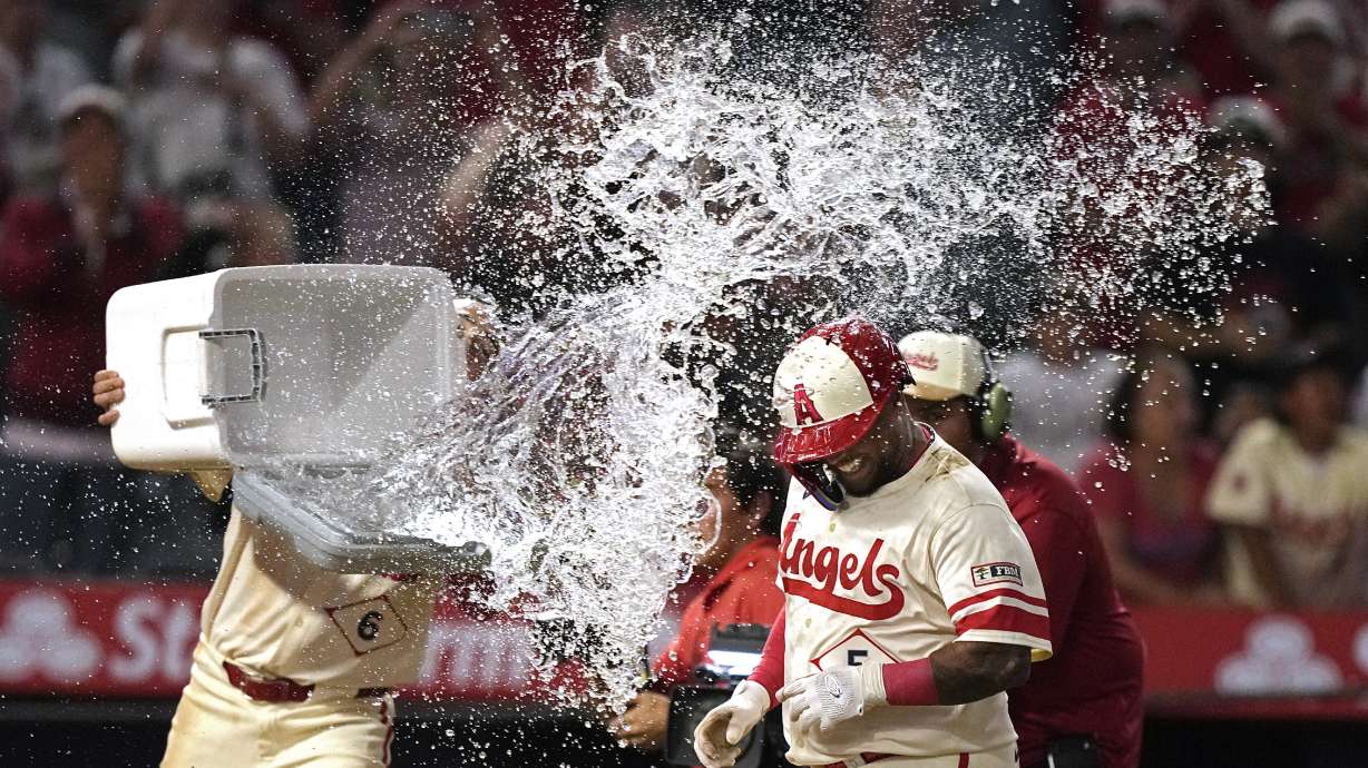 Los Angeles Angels' Willie Calhoun, is hit with water by Anthony Rendon as he scores after hitting a walk-off two-run home run during the 10th inning of a baseball game against the Seattle Mariners Friday, July 12, 2024, in Anaheim, Calif.