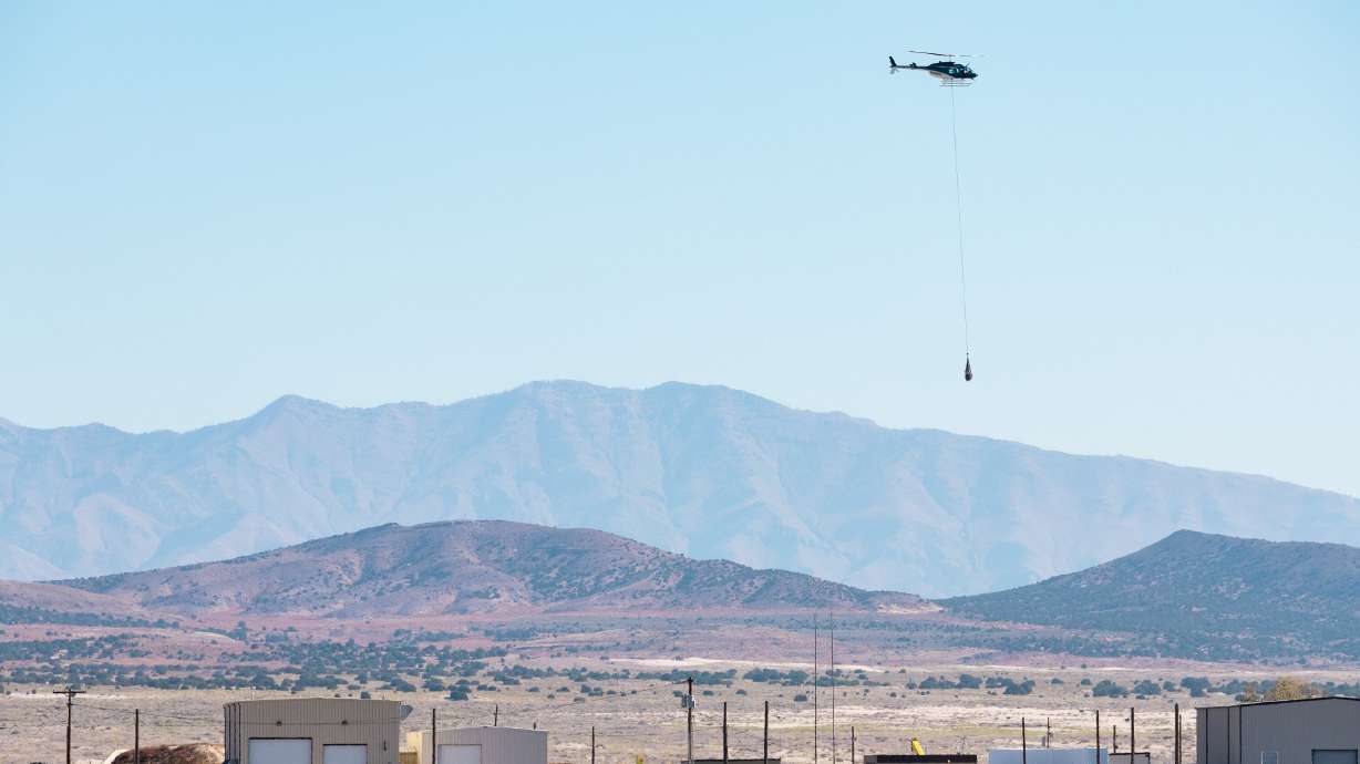 A helicopter long lines the capsule containing a sample collected from the Bennu asteroid as part of NASA’s Osiris-Rex mission from where it was retrieved to a clean room at the U.S. Army’s Dugway Proving Ground in Dugway on Sunday, Sept. 24, 2023.