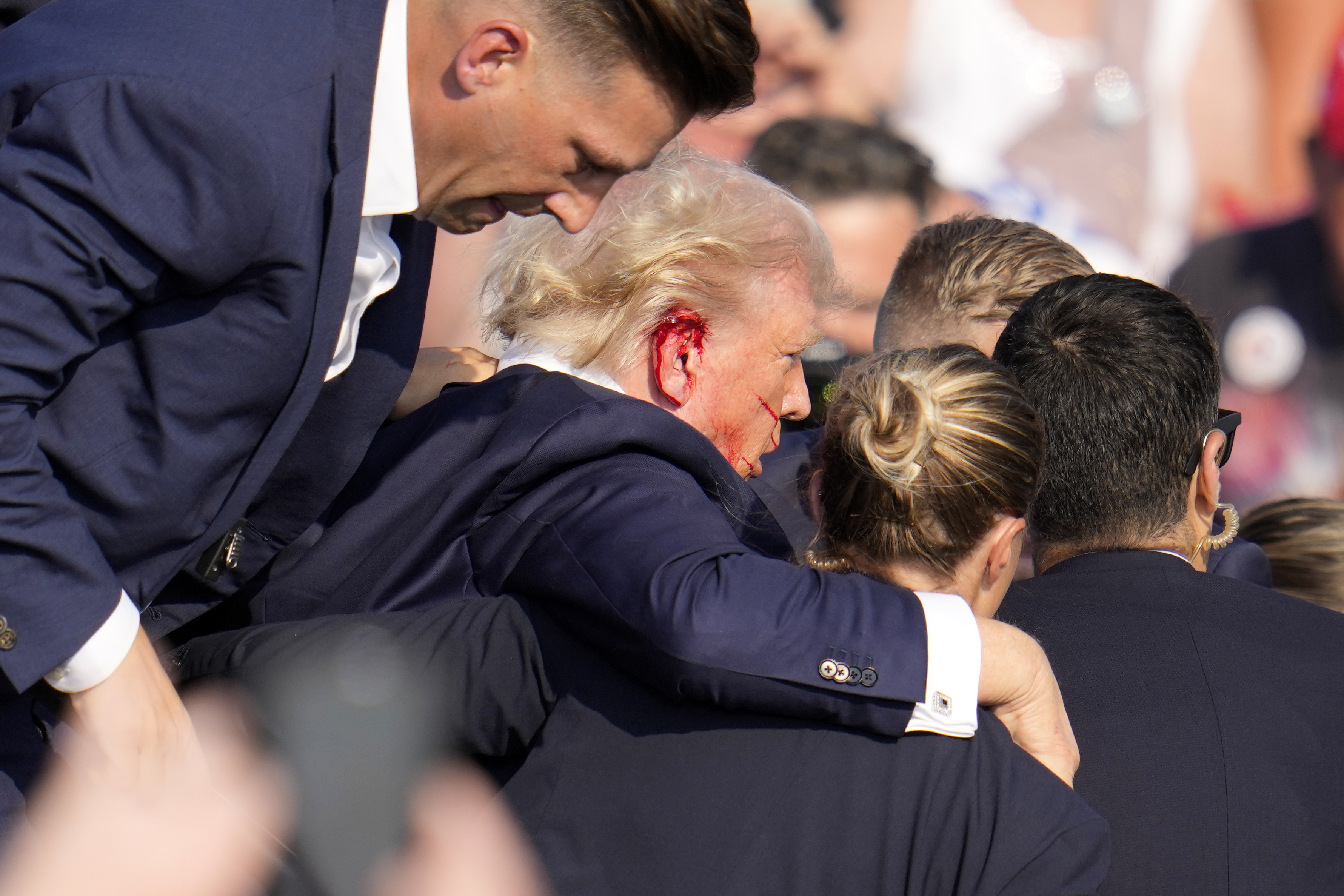 Republican presidential candidate former President Donald Trump is helped off the stage at a campaign event in Butler, Pa., on Saturday.