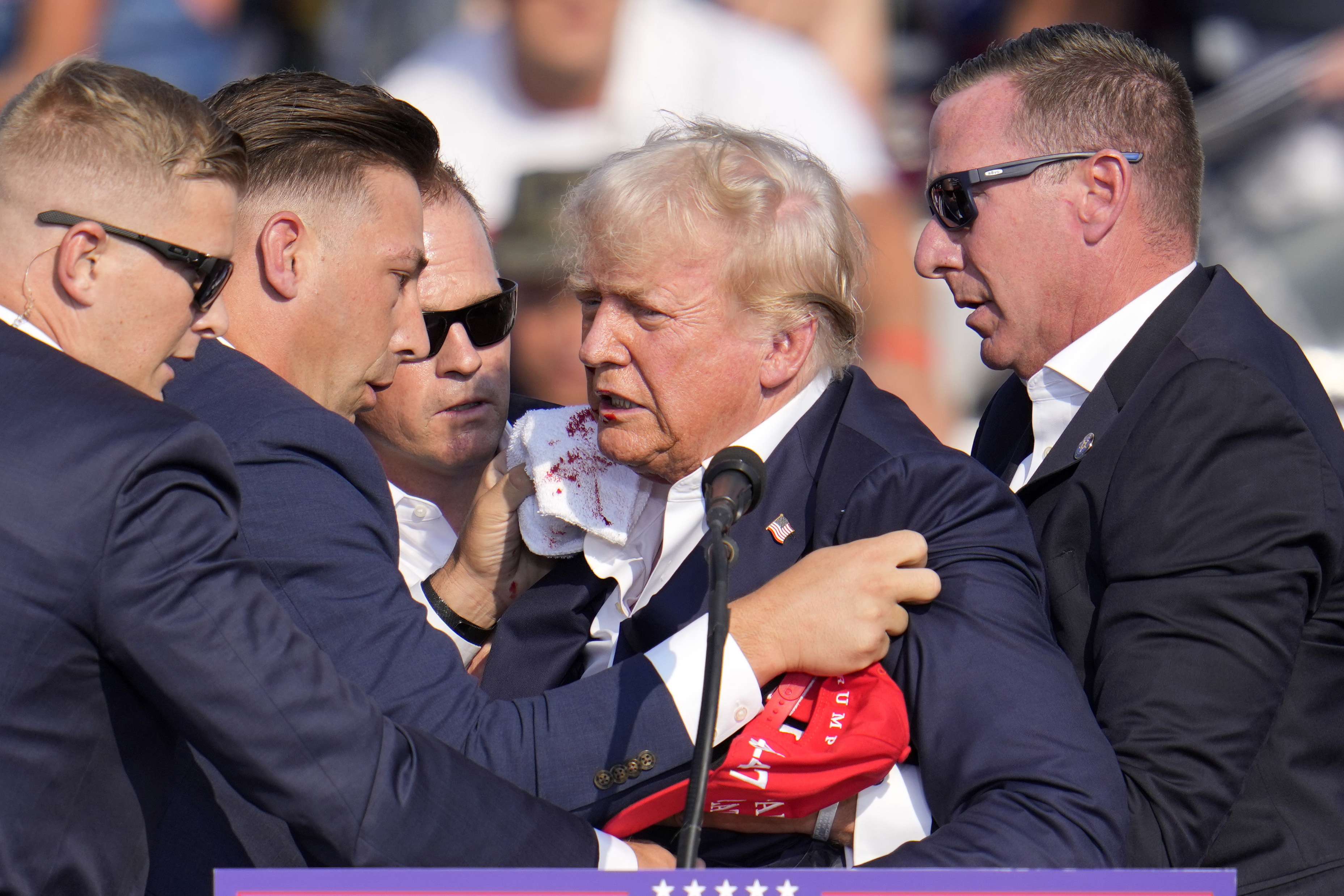 Republican presidential candidate former President Donald Trump is helped off the stage at a campaign event in Butler, Pa., on Saturday.