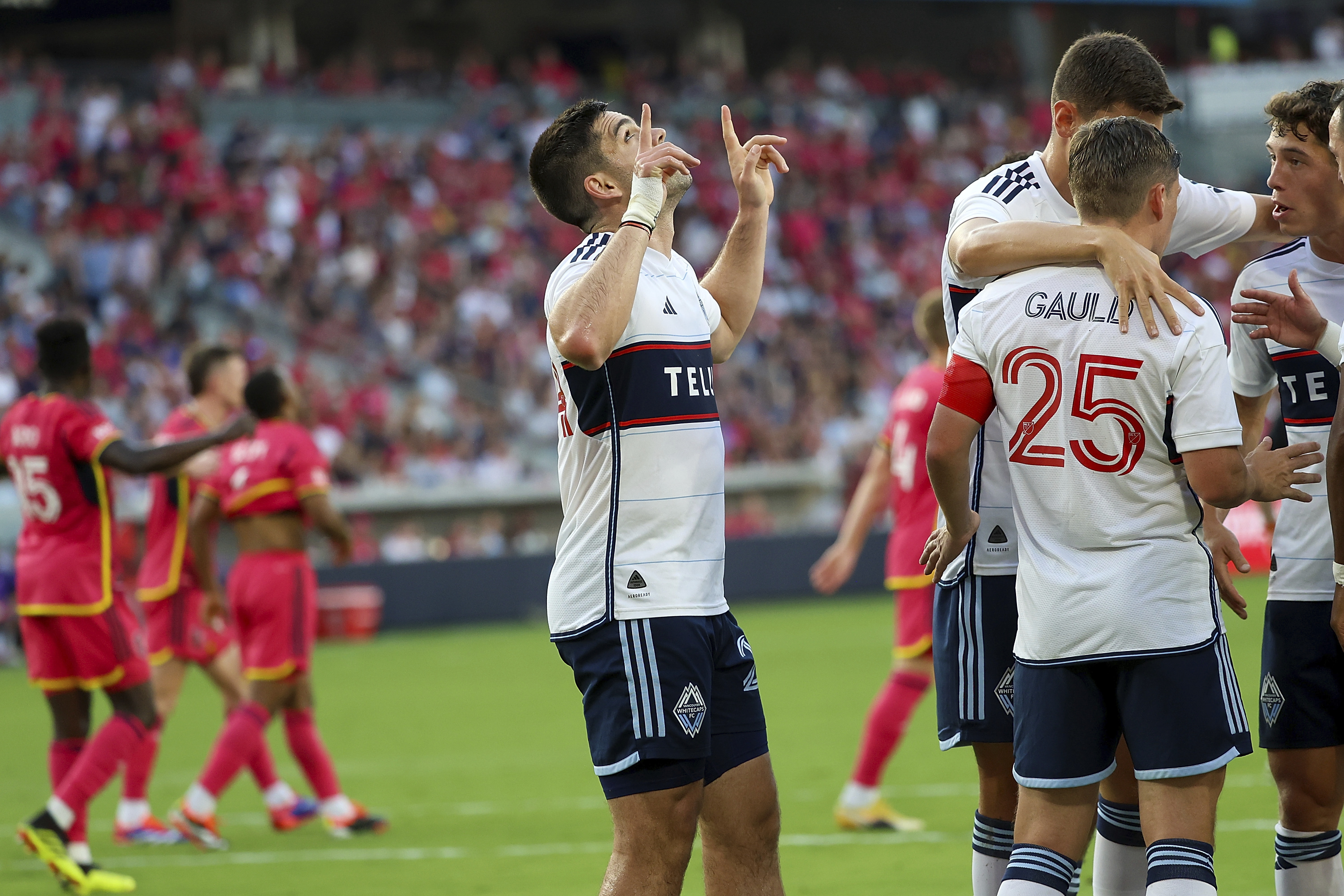 Vancouver Whitecaps' Brian White, center, gestures skyward after scoring during the first half of an MLS soccer match against St. Louis City, Saturday, July 13, 2024, in St. Louis. 