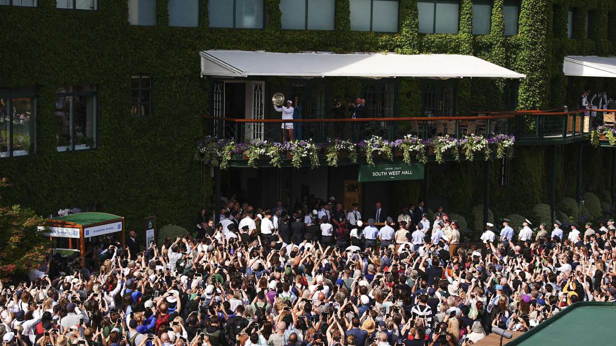Barbora Krejcikova of the Czech Republic holds up the winners trophy after she defeated Jasmine Paolini of Italy in the women's singles final at the Wimbledon tennis championships in London, Saturday, July 13, 2024.
