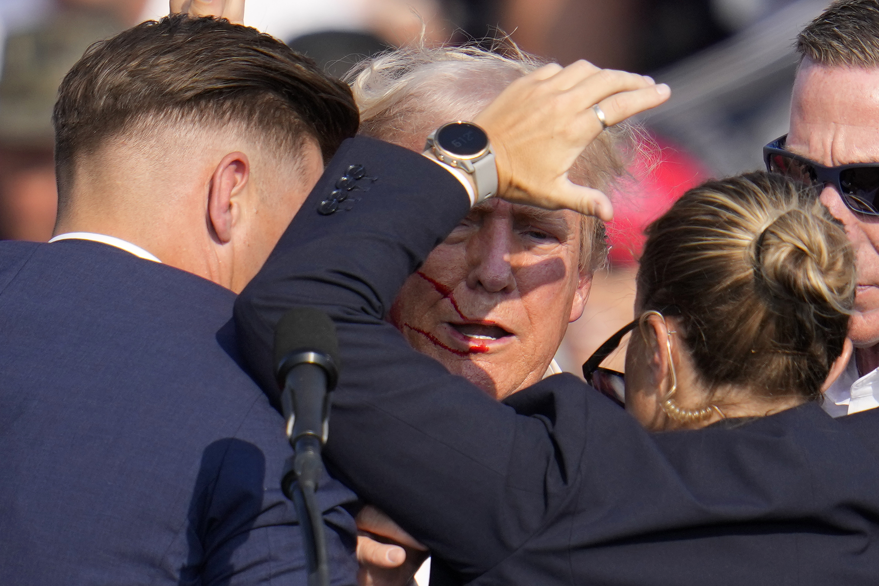 Republican presidential candidate former President Donald Trump is helped off the stage by U.S. Secret Service agents at a campaign event in Butler, Pa., on Saturday.